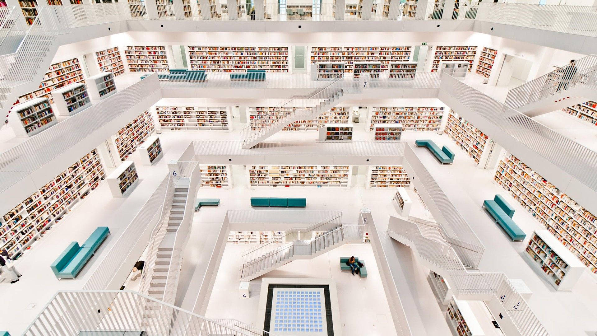 Modern 桌布 壁紙 — 現代多層圖書館的鳥瞰圖，白色建築和青綠色座椅被書架環繞。