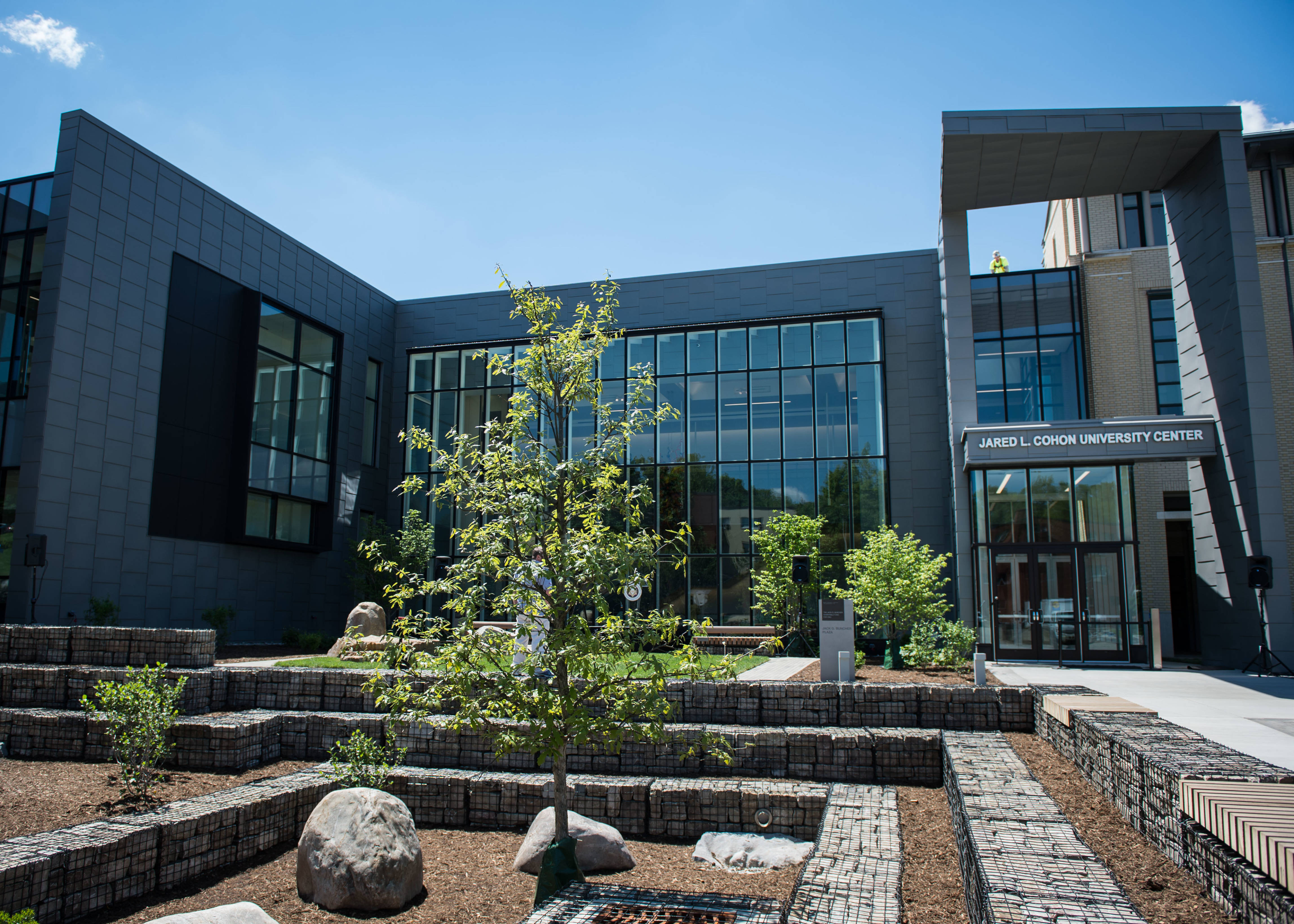 Building 桌布 壁紙 — 現代大學中心，玻璃外牆和石頭露台花園，在清澈的藍天下。