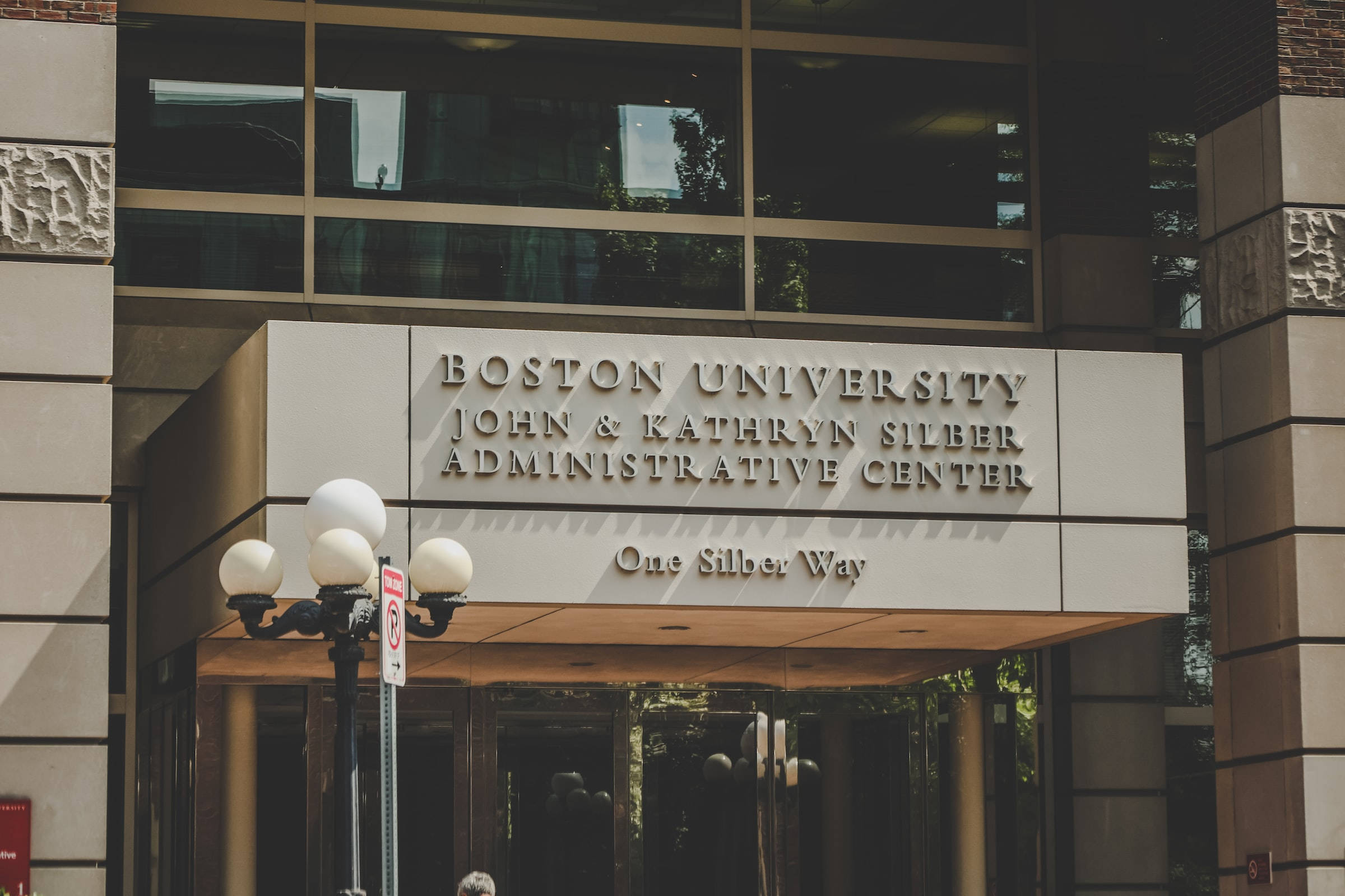Building 桌布 壁紙 — 現代大學建築入口，配有玻璃窗和刻有「Boston University John & Kathryn Silber Administrative Center」的石牌。