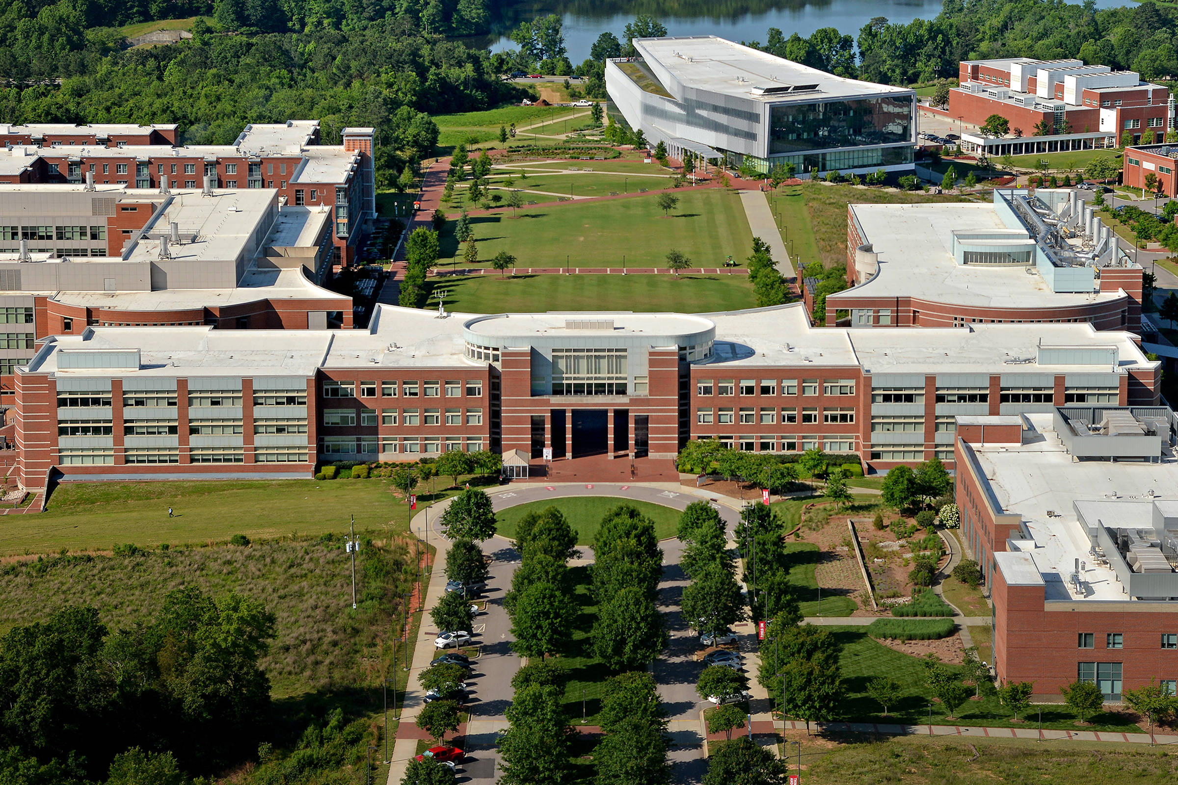 North Carolina 桌布 壁紙 — 現代大學校園的鳥瞰圖，有紅磚建築、綠色草坪和背景中的河流。