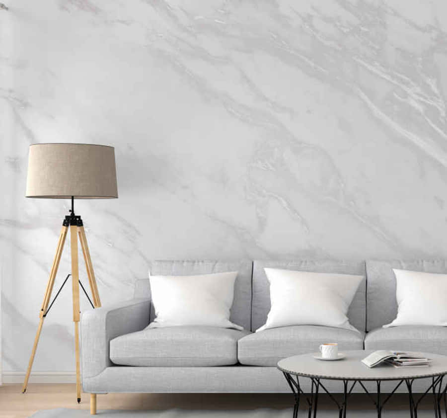 Aesthetic Gray Marble 桌布 壁紙 — 現代客廳中，灰色沙發搭配白色靠枕，靠著白色大理石壁紙牆面，旁邊有一盞三腳落地燈。