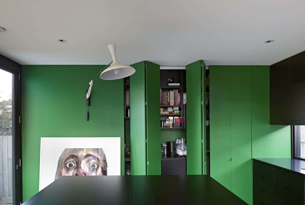 Kitchen Design 桌布 壁紙 — 現代室內設計，大膽的綠色牆壁、黑色家具和白色吊燈下的大型裱框肖像。
