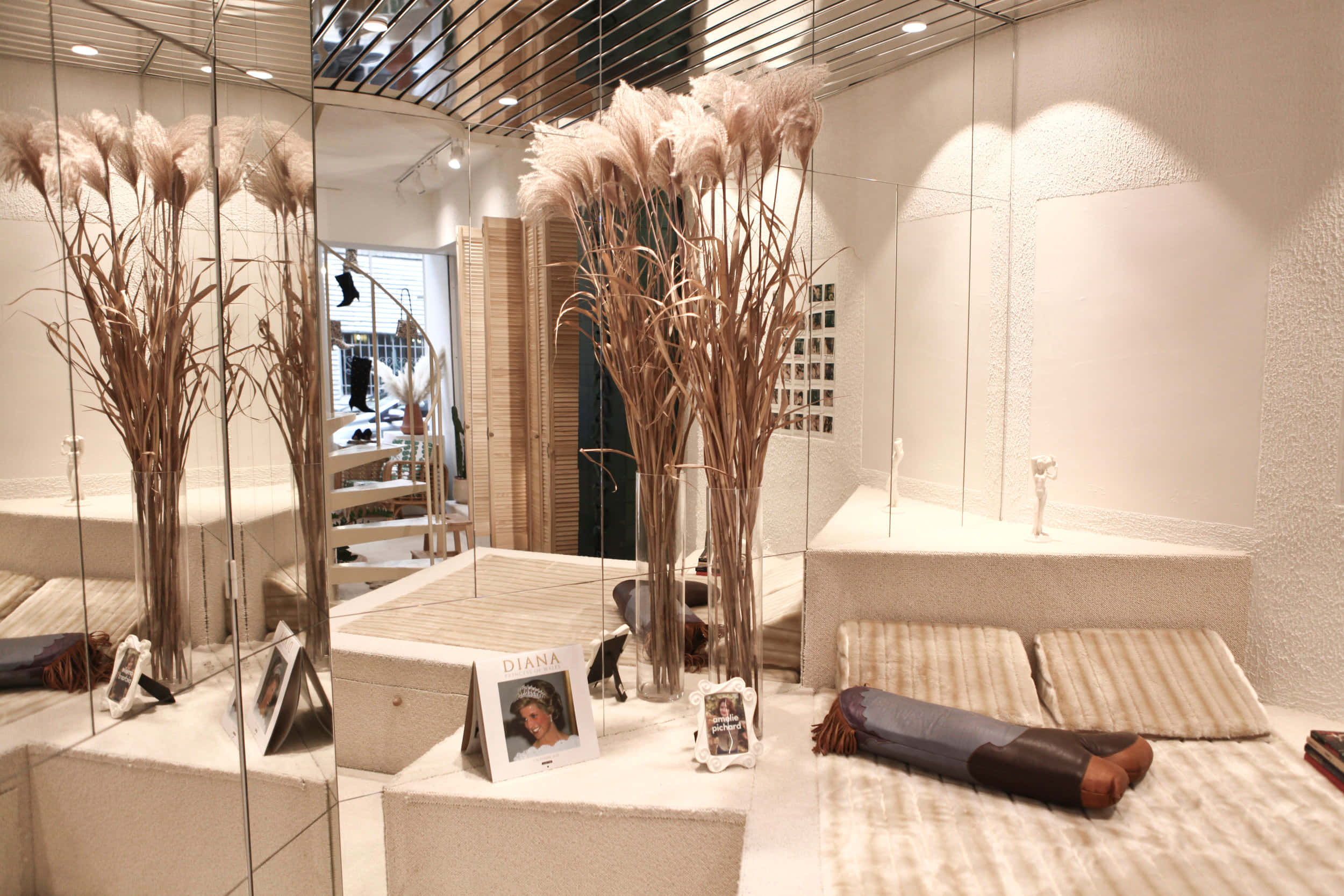 Interior Design 桌布 壁紙 — 現代室內設計，鏡面牆壁映照出高大的蒲葦花瓶和米色平台床上的條紋靠墊。