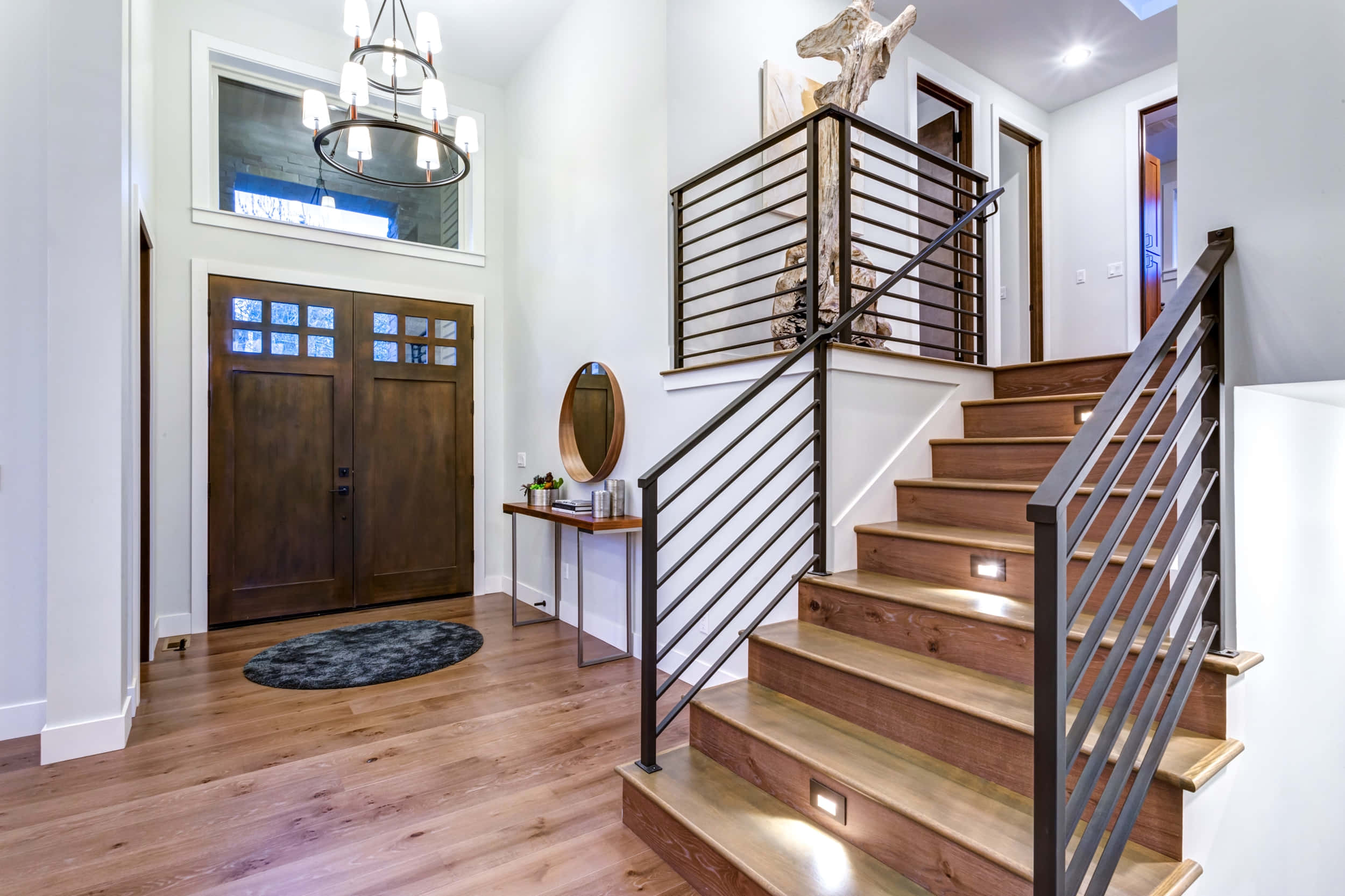 stairs 桌布 壁紙 — 現代家居入口，設有木樓梯、金屬欄杆及階梯下的溫暖照明。