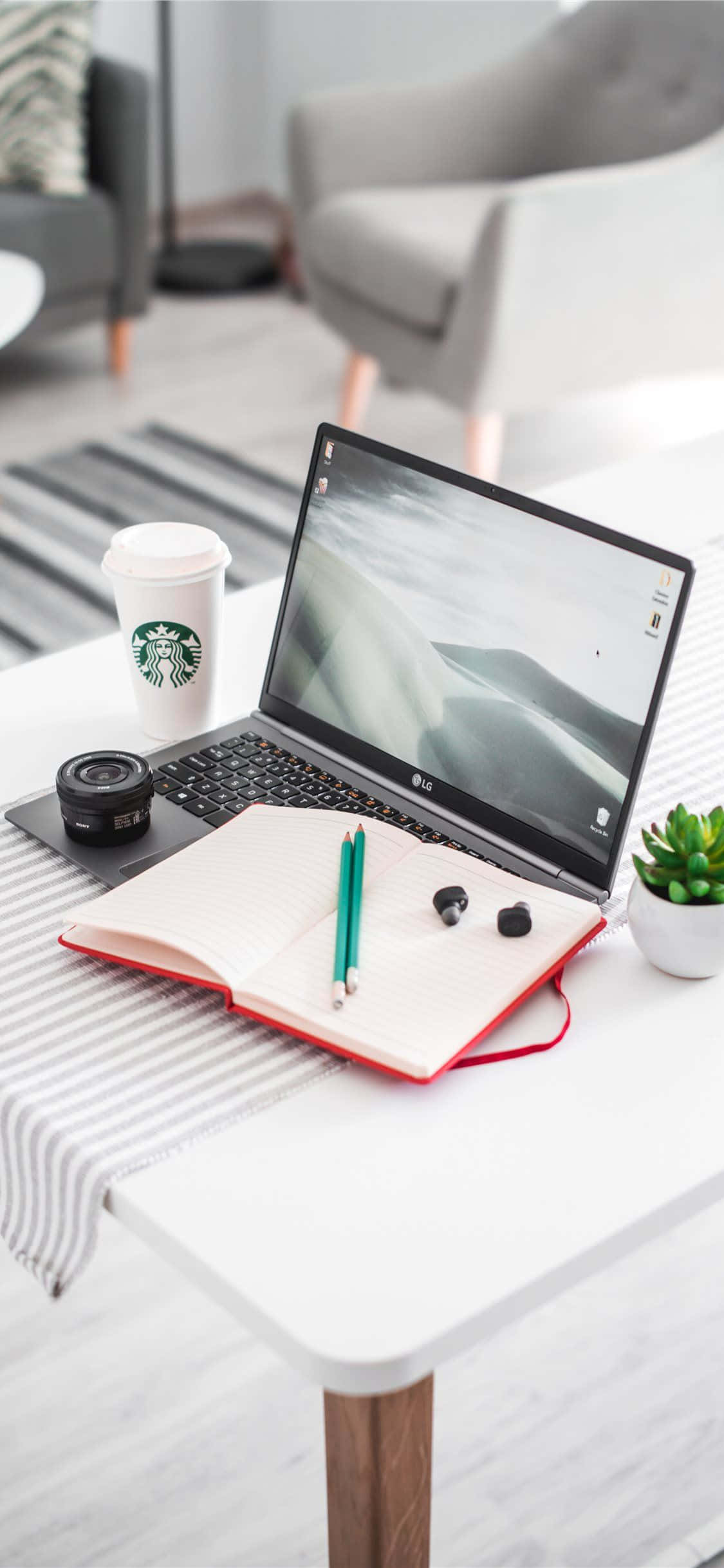 Desk 桌布 壁紙 — 現代工作空間，在舒適的客廳中，白色桌子上有筆記型電腦、筆記本、咖啡和小植物。