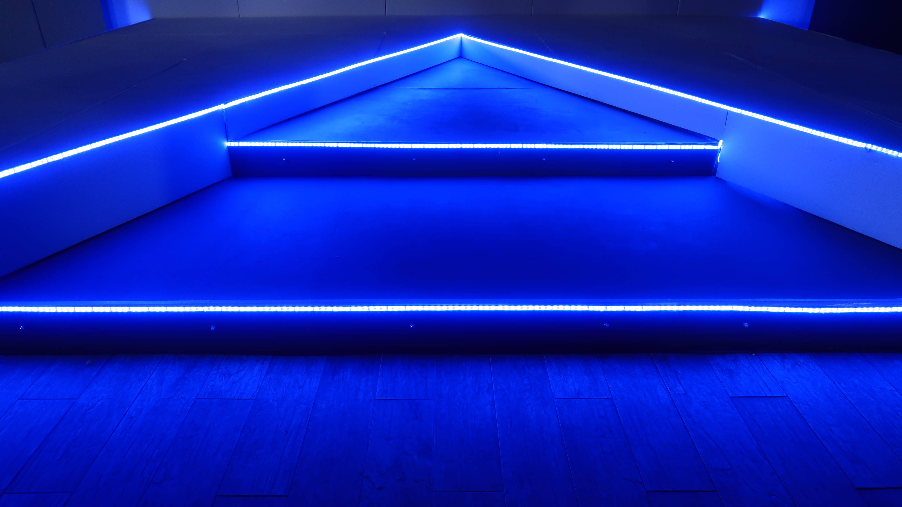 藍色 桌布 壁紙 — 現代幾何樓梯沐浴在冷藍色LED燈光中，營造出未來感和極簡主義氛圍。