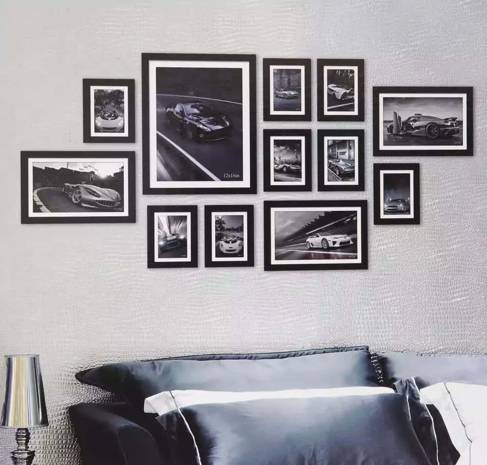 Wall Collage 桌布 壁紙 — 現代床鋪上方，質感灰色牆壁上展示著時尚跑車動態的黑白裱框照片畫廊牆。