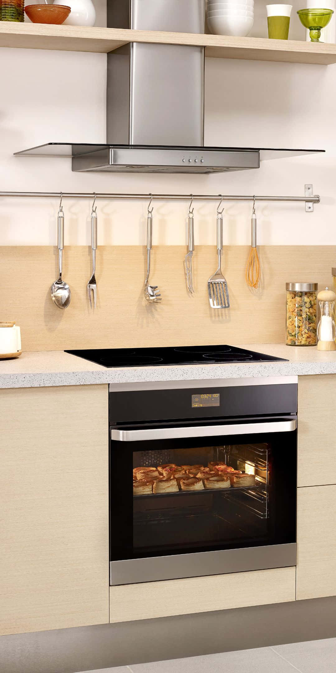 Pixel 3 Kitchen 桌布 壁紙 — 現代廚房，不鏽鋼烤箱烤雞，廚具整齊掛在乾淨的檯面上方。
