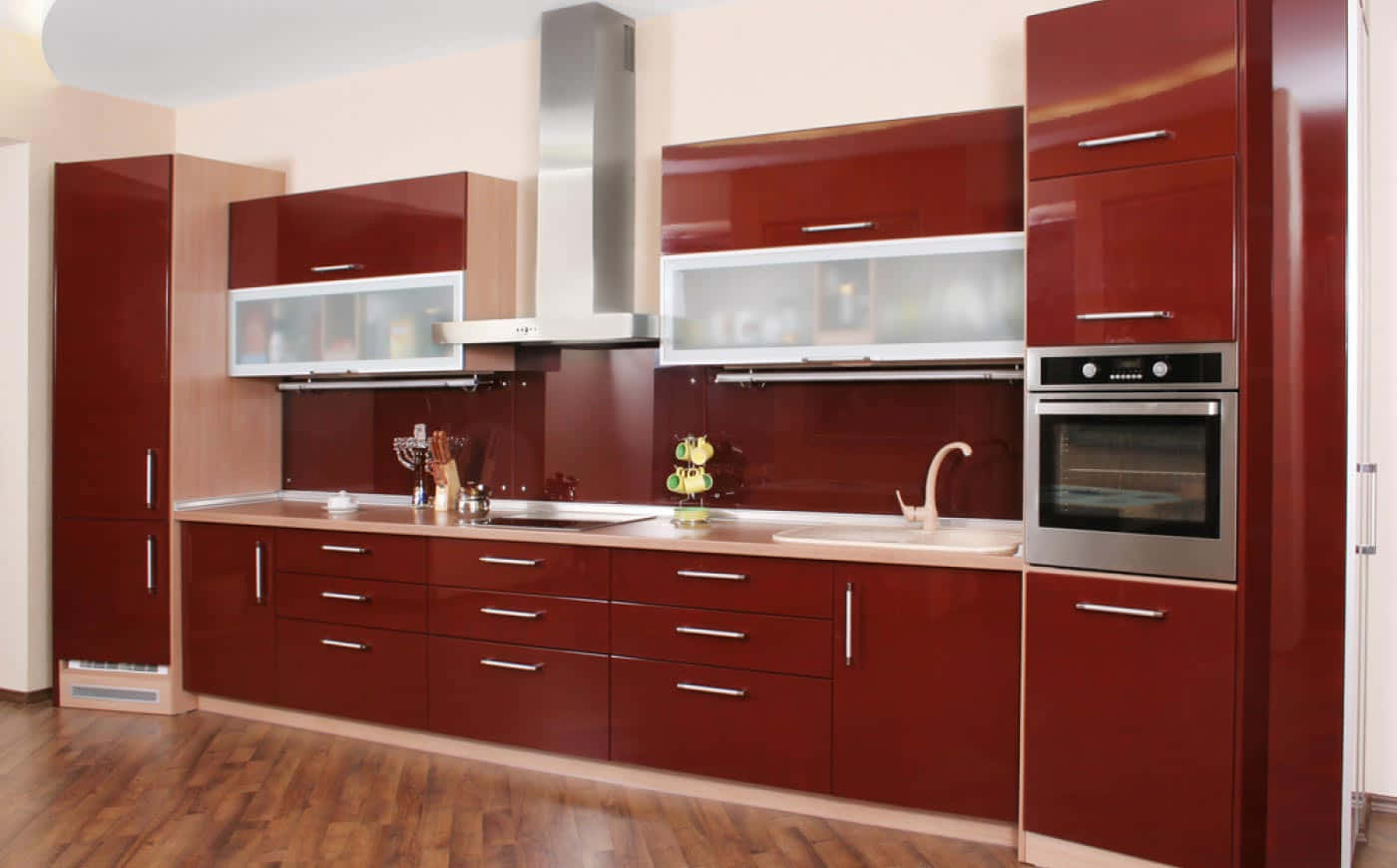 Modular Kitchen 桌布 壁紙 — 現代廚房，配備亮面紅色櫥櫃、不鏽鋼電器及木地板，在明亮燈光下。