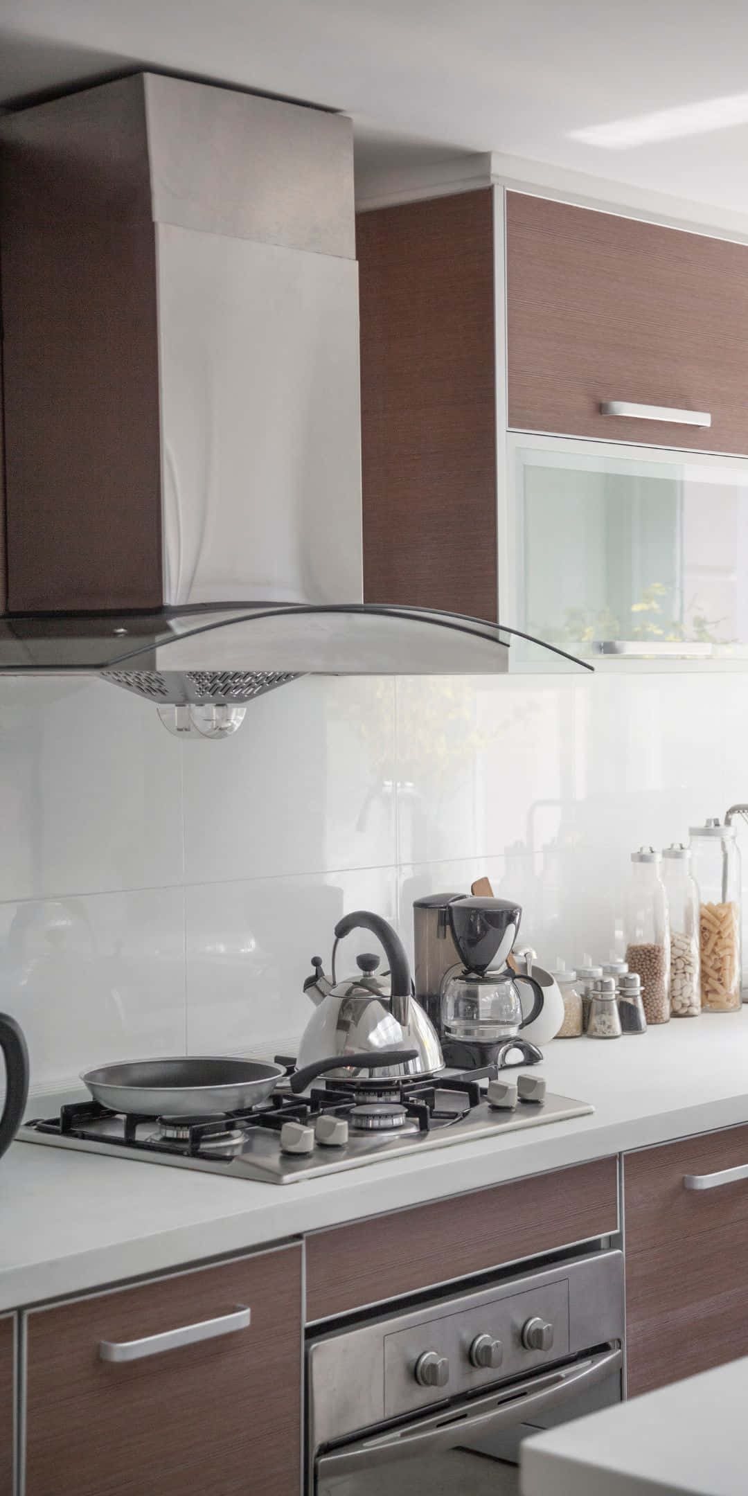 Pixel 3 Kitchen 桌布 壁紙 — 現代廚房，配有不鏽鋼爐灶、水壺和木製櫥櫃，在明亮的日光下。