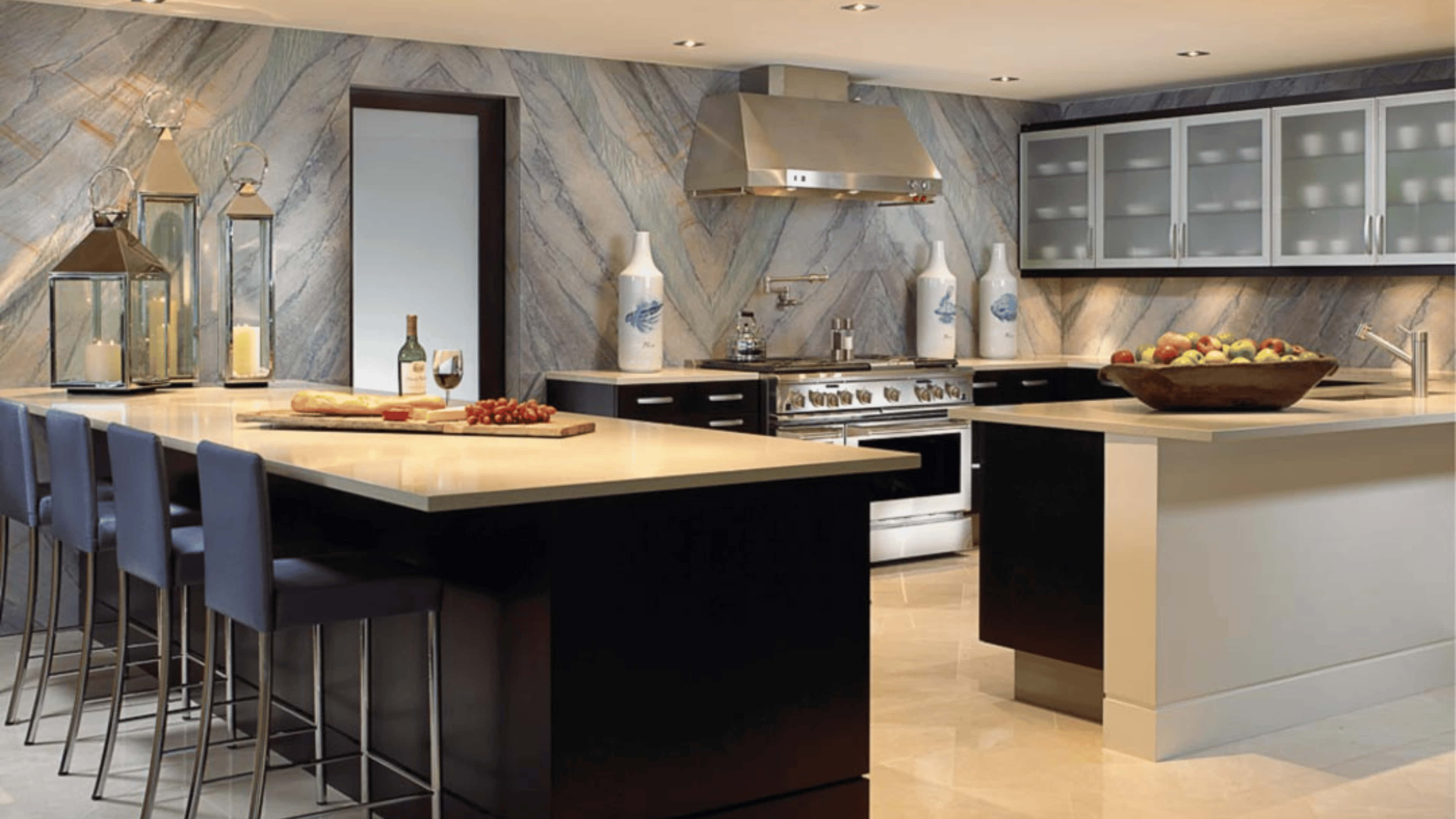 4K Kitchen 桌布 壁紙 — 現代廚房，配有大理石防濺板、不鏽鋼電器、深色中島和藍色吧檯椅。