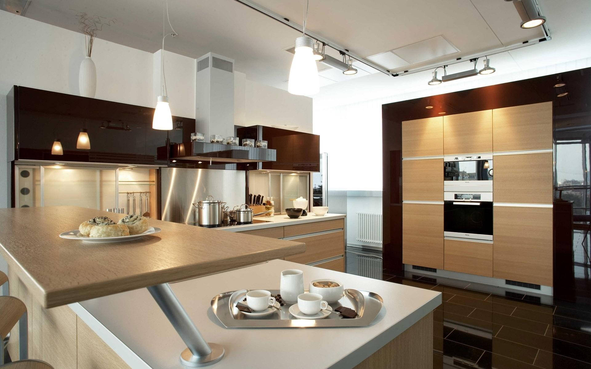 Kitchen Design 桌布 壁紙 — 現代廚房，配有木製櫥櫃、不鏽鋼電器，以及中央島上的早餐物品，下方是明亮的吊燈。