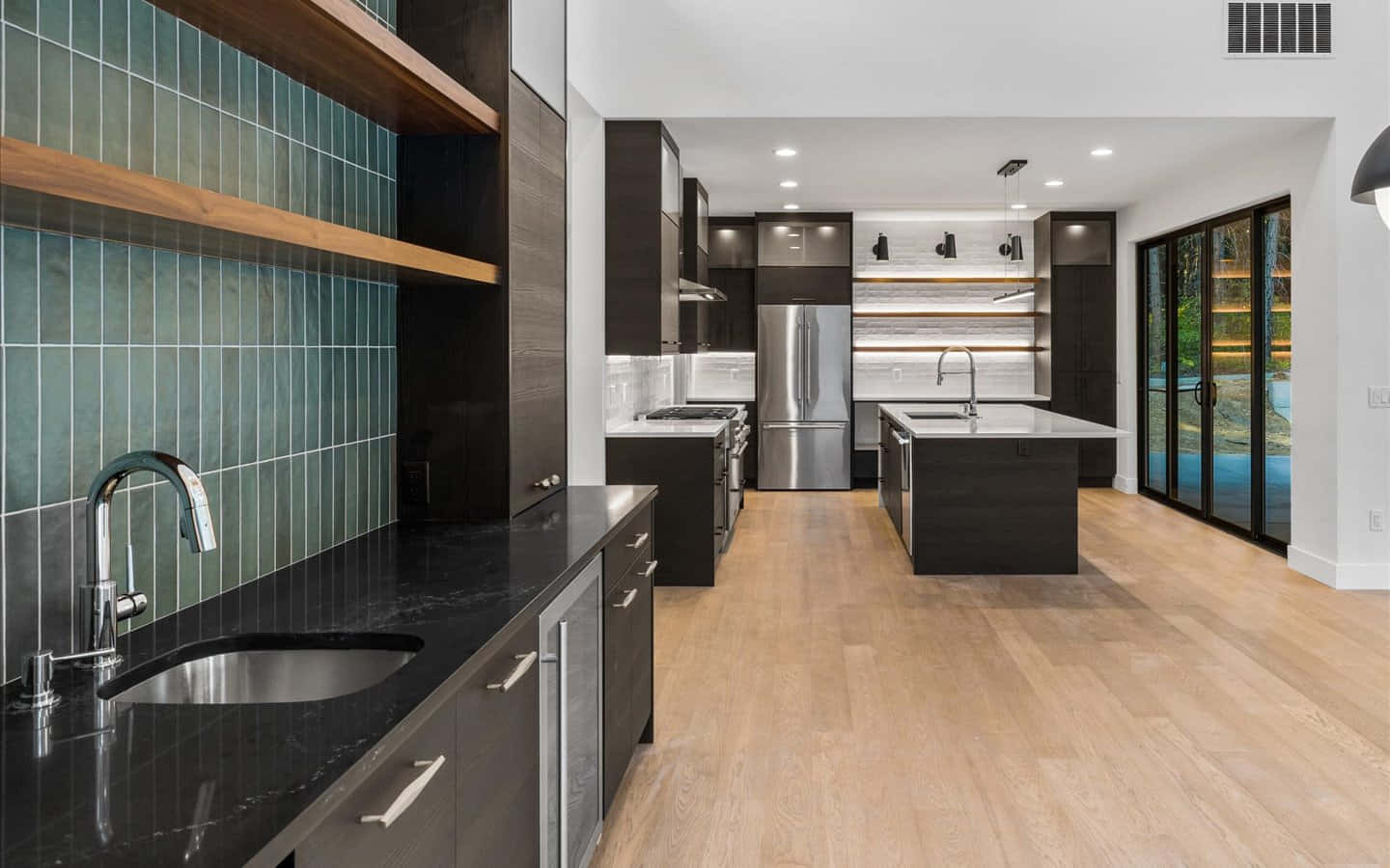 1440p Kitchen 桌布 壁紙 — 現代廚房，配有深色木櫃、黑色檯面、青綠色瓷磚防濺板和淺色木地板。