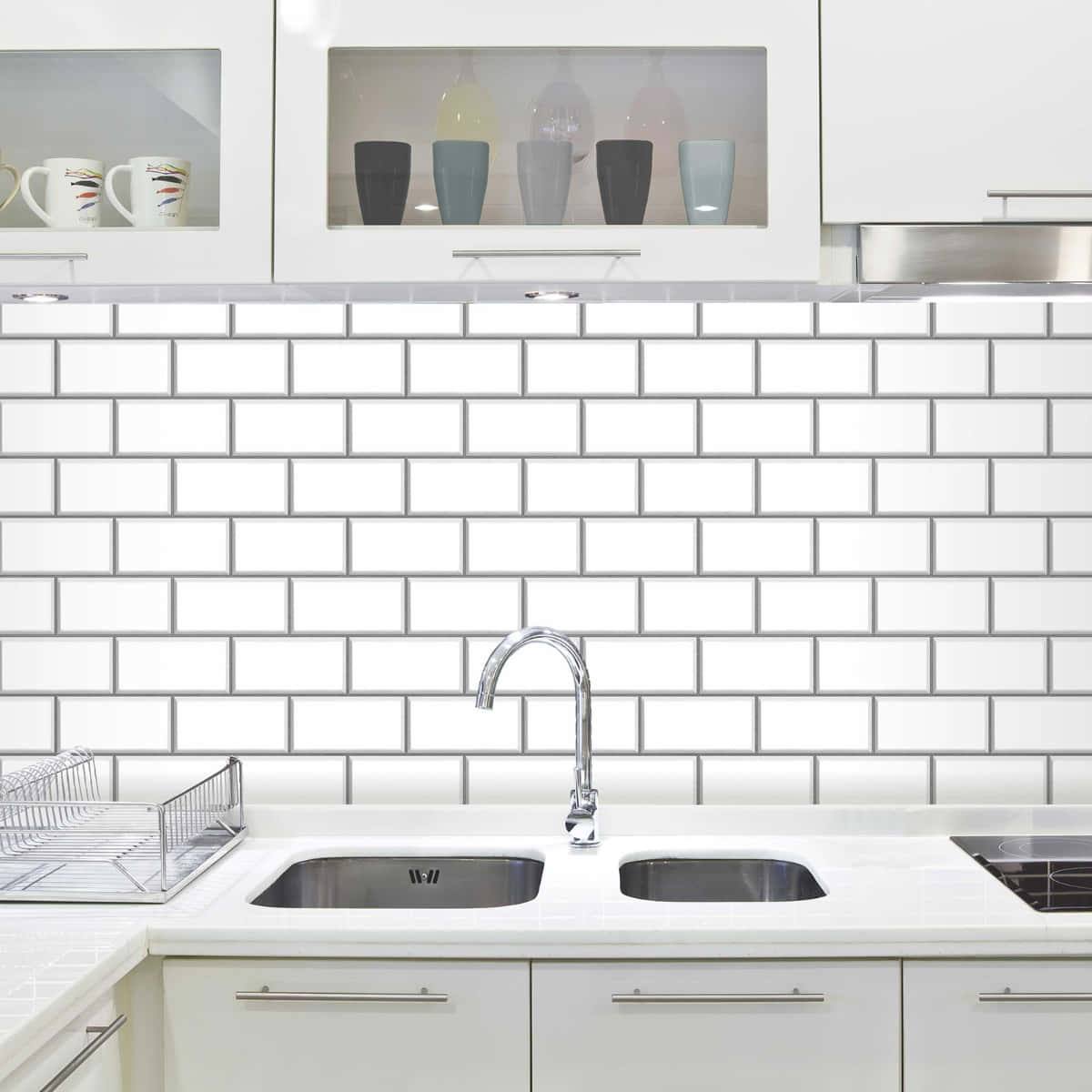 Tiles 桌布 壁紙 — 現代廚房，配有白色地鐵磚防濺板、不鏽鋼水槽和玻璃前櫃，展示色彩繽紛的馬克杯和玻璃杯。