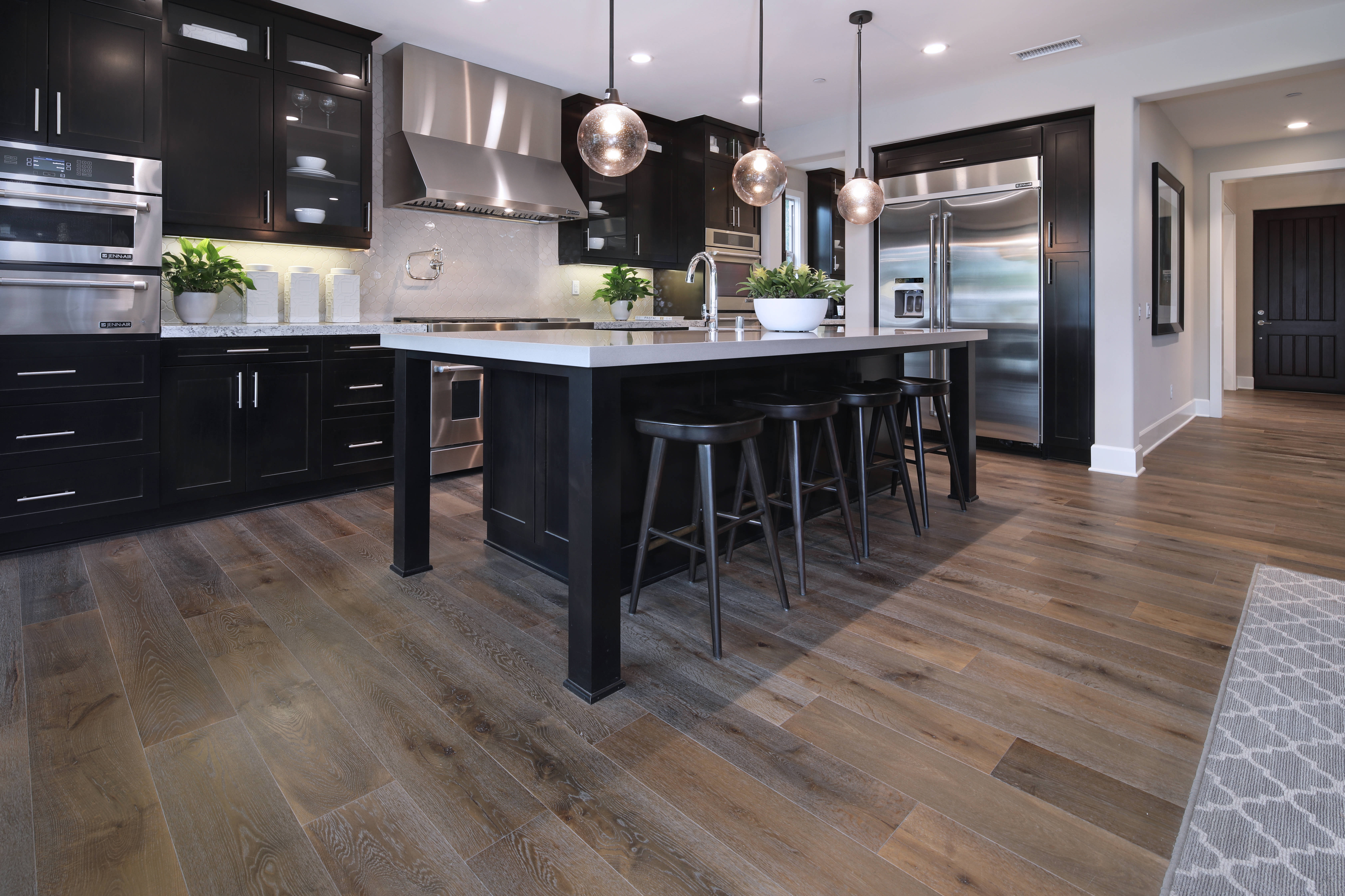 Kitchen Design 桌布 壁紙 — 現代廚房，配有黑色櫥櫃、不鏽鋼電器及吊燈下的木地板。