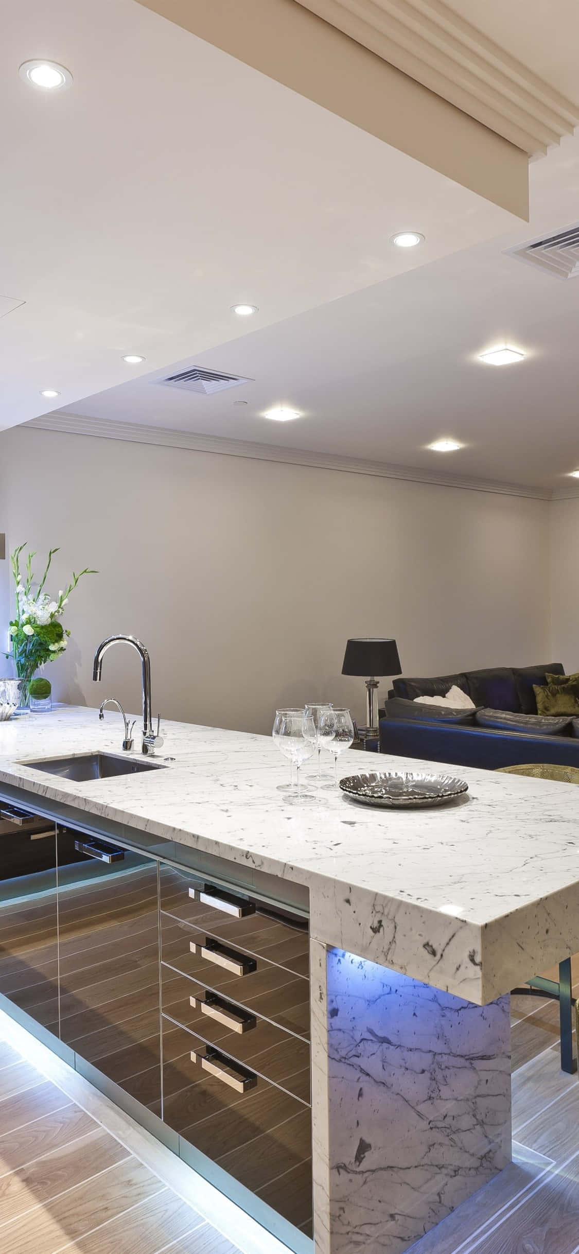 kitchen 桌布 壁紙 — 現代廚房島檯，配備大理石檯面及藍色重點照明，位於時尚櫥櫃下方。