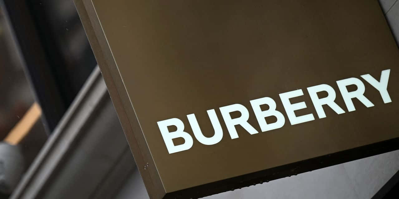 Burberry 桌布 壁紙 — 現代建築外牆上安裝的時尚棕色 Burberry 標誌特寫，帶有粗體白色字體。