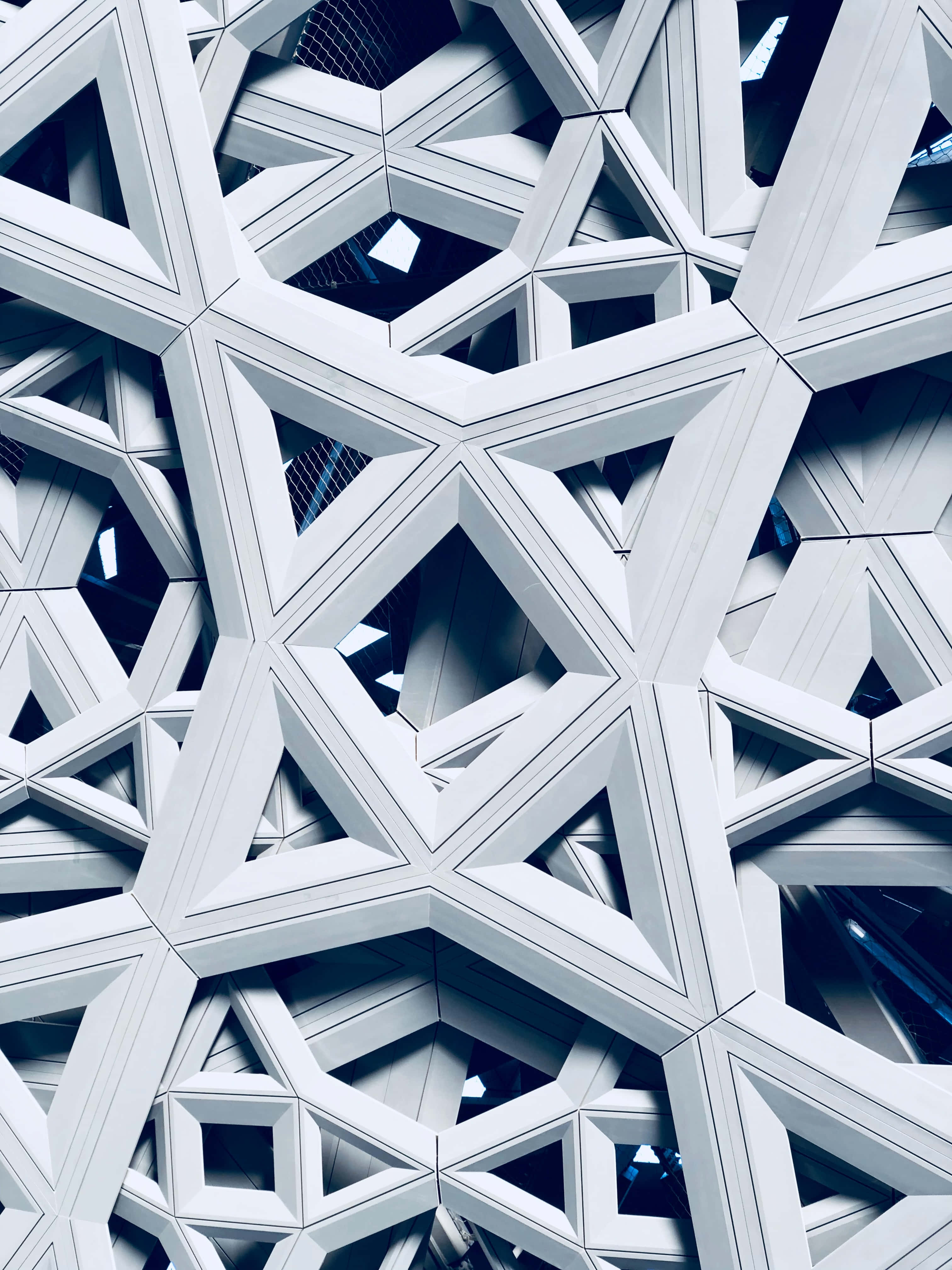 3D 桌布 壁紙 — 現代建築物外牆的特寫，帶有複雜的白色幾何圖案和深藍色陰影。