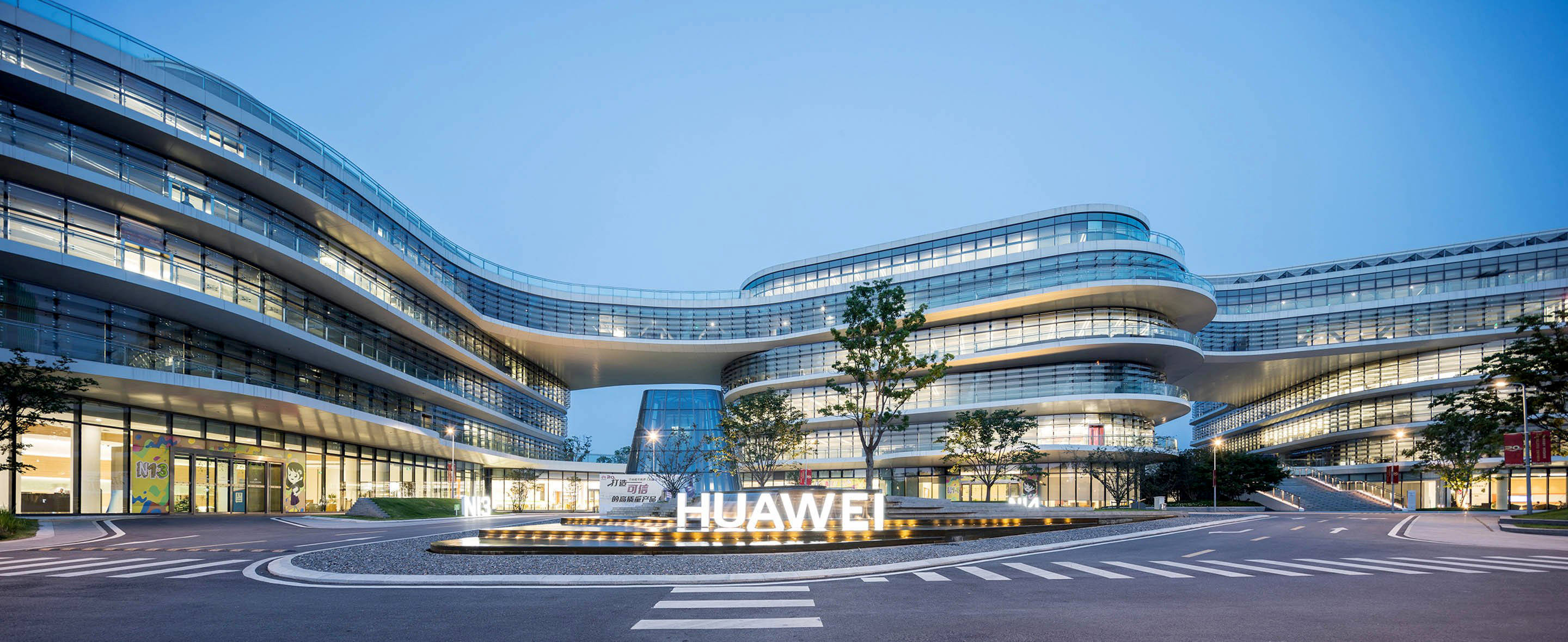 Nanjing 桌布 壁紙 — 現代彎曲玻璃華為建築，在黃昏時亮起，窗戶發光，標誌突出。