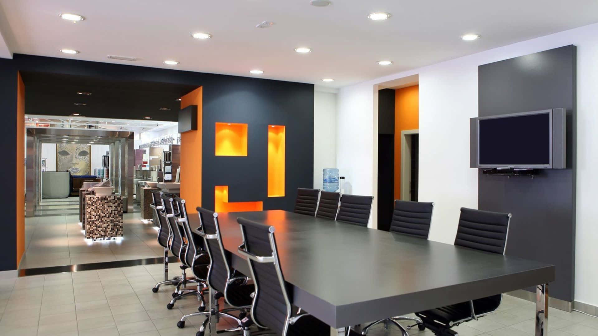 Modern Office 桌布 壁紙 — 現代會議室，配有時尚黑色桌椅和鮮豔橙色特色牆，上方有明亮天花板燈。