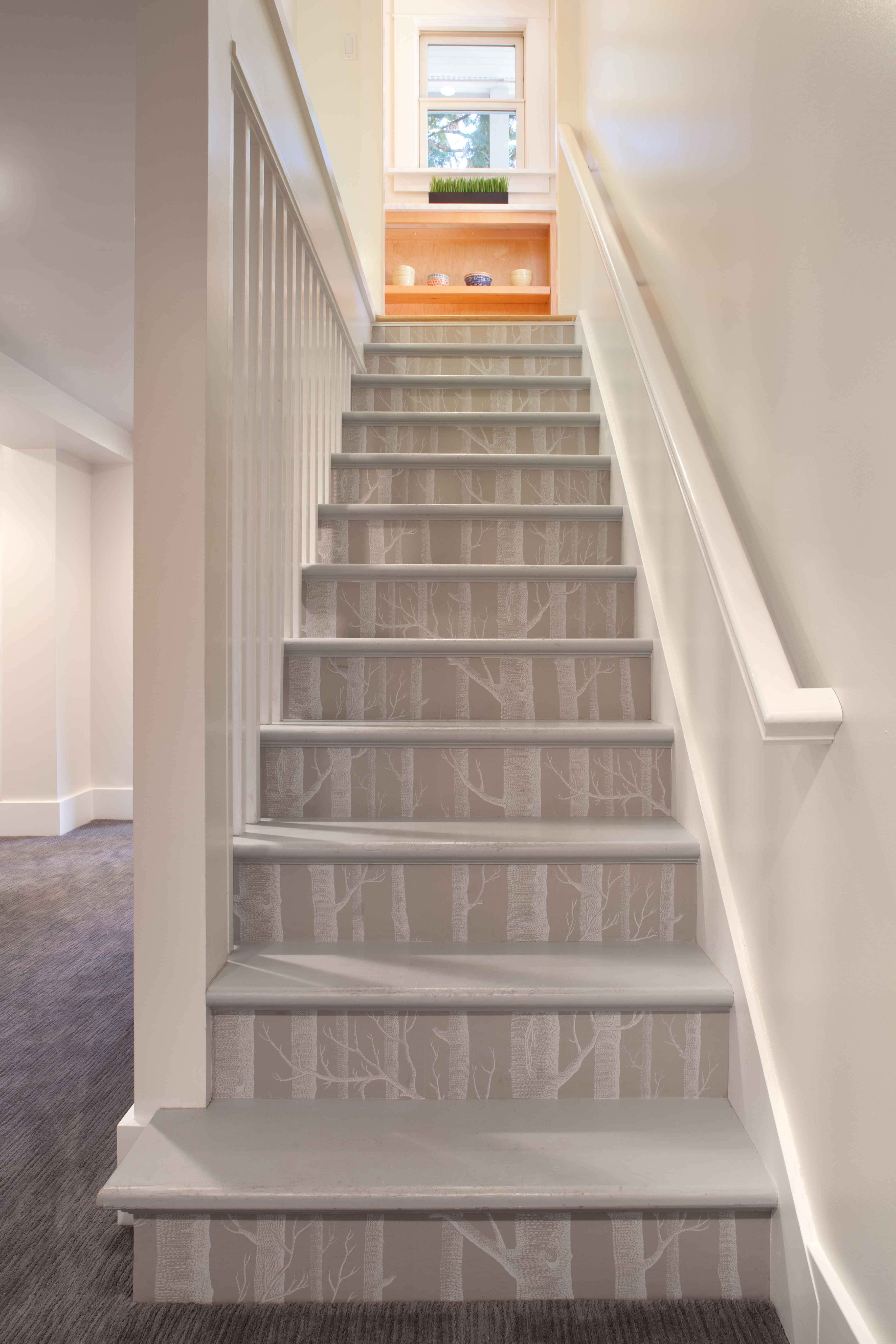 stairs 桌布 壁紙 — 現代樓梯，灰色階梯飾有精緻的白色樹枝圖案，通往帶有木架子的明亮窗戶。