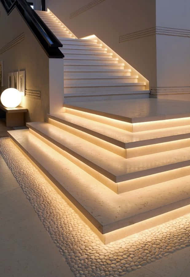 Minimalist Design 桌布 壁紙 — 現代樓梯，配有溫暖的底部照明和鵝卵石地板，位於極簡風格的室內空間。