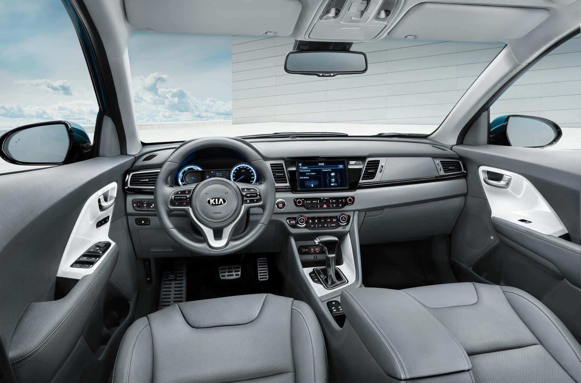 Kia Niro 桌布 壁紙 — 現代汽車內部，配備灰色皮革座椅和數位儀表板，在明亮的日光下。