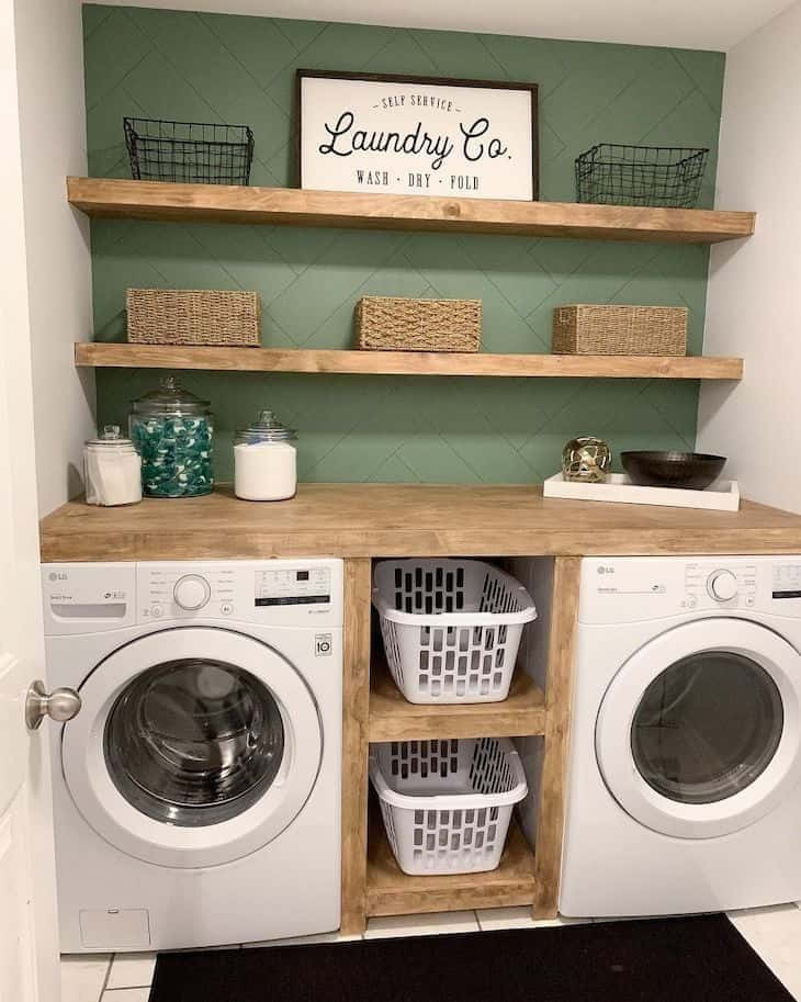 Laundry Room 桌布 壁紙 — 現代洗衣房，配有白色前置式洗衣機、木架、綠色瓷磚牆和用於儲物的編織籃。