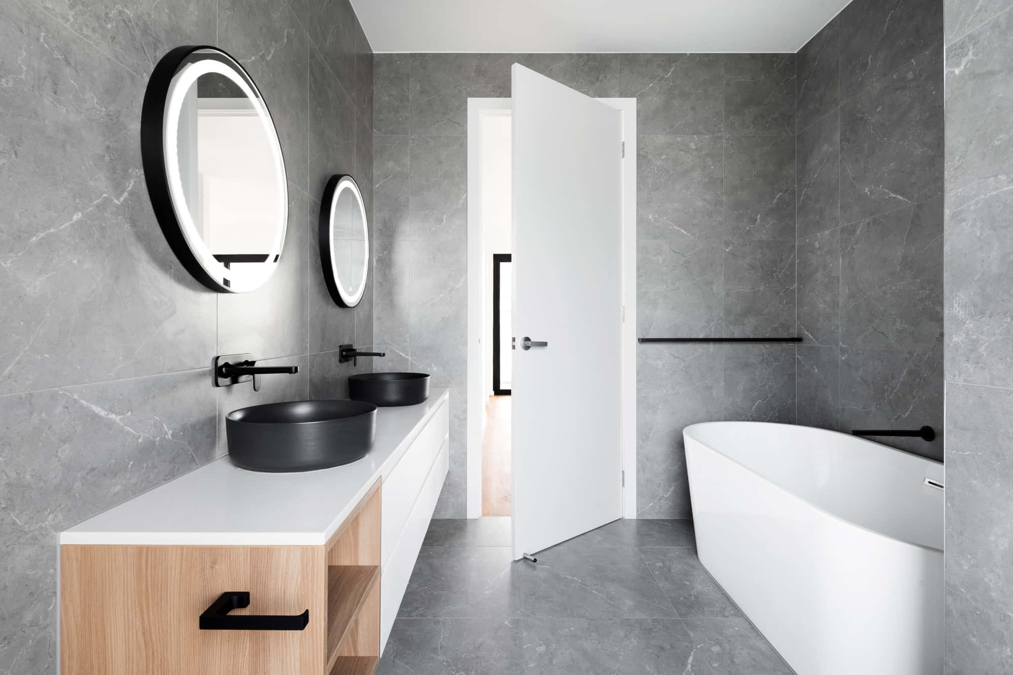 bathroom 桌布 壁紙 — 現代浴室，灰色大理石牆壁，黑色洗手盆，獨立式白色浴缸，光線明亮。