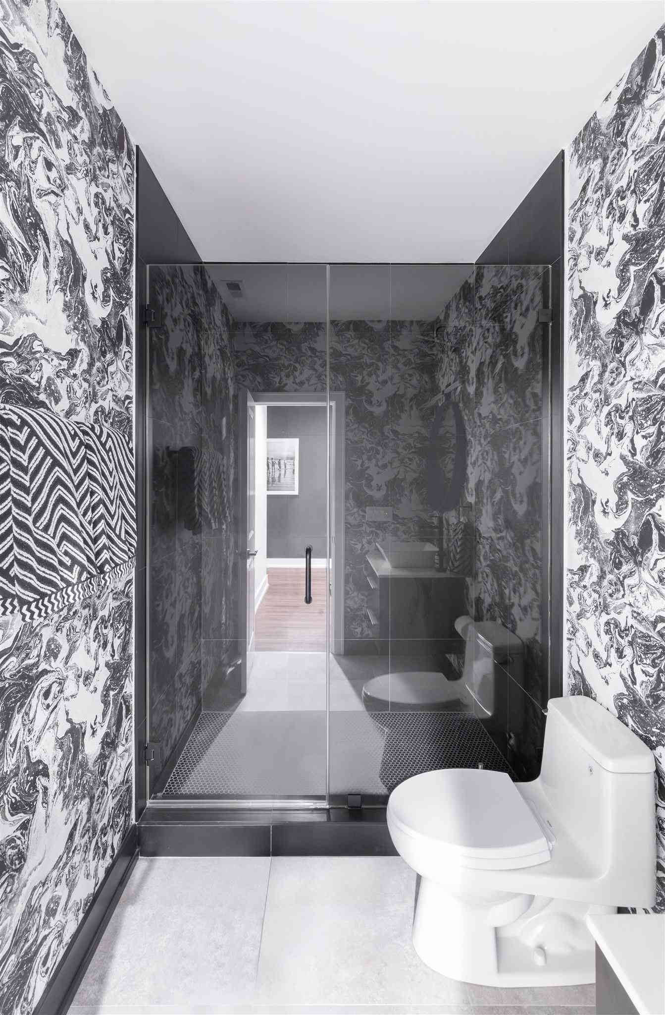 bathroom 桌布 壁紙 — 現代浴室，配有大膽的黑白圖案壁紙和玻璃淋浴間。