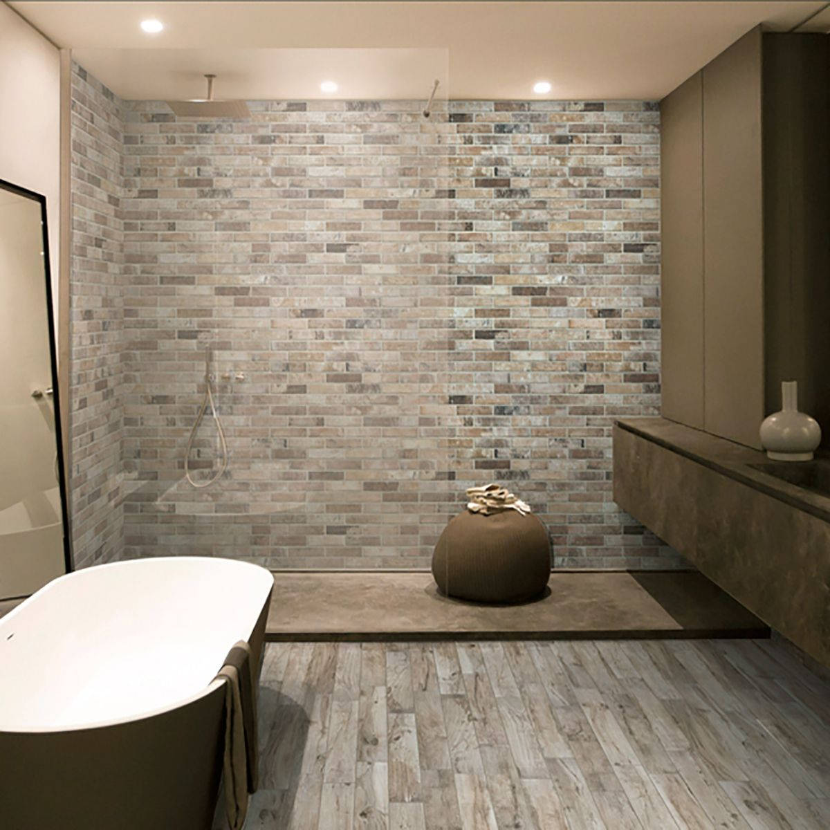 bathroom 桌布 壁紙 — 現代浴室，配有石磚淋浴牆、木地板、獨立式浴缸，以及溫暖天花板燈下的簡約裝飾。