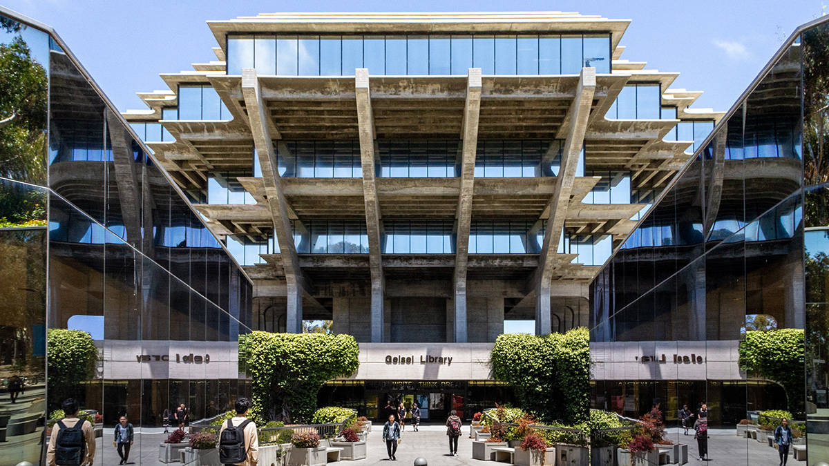  壁紙 — 現代混凝土和玻璃圖書館建築，設有分層陽台和反射表面，在明亮的藍天下。