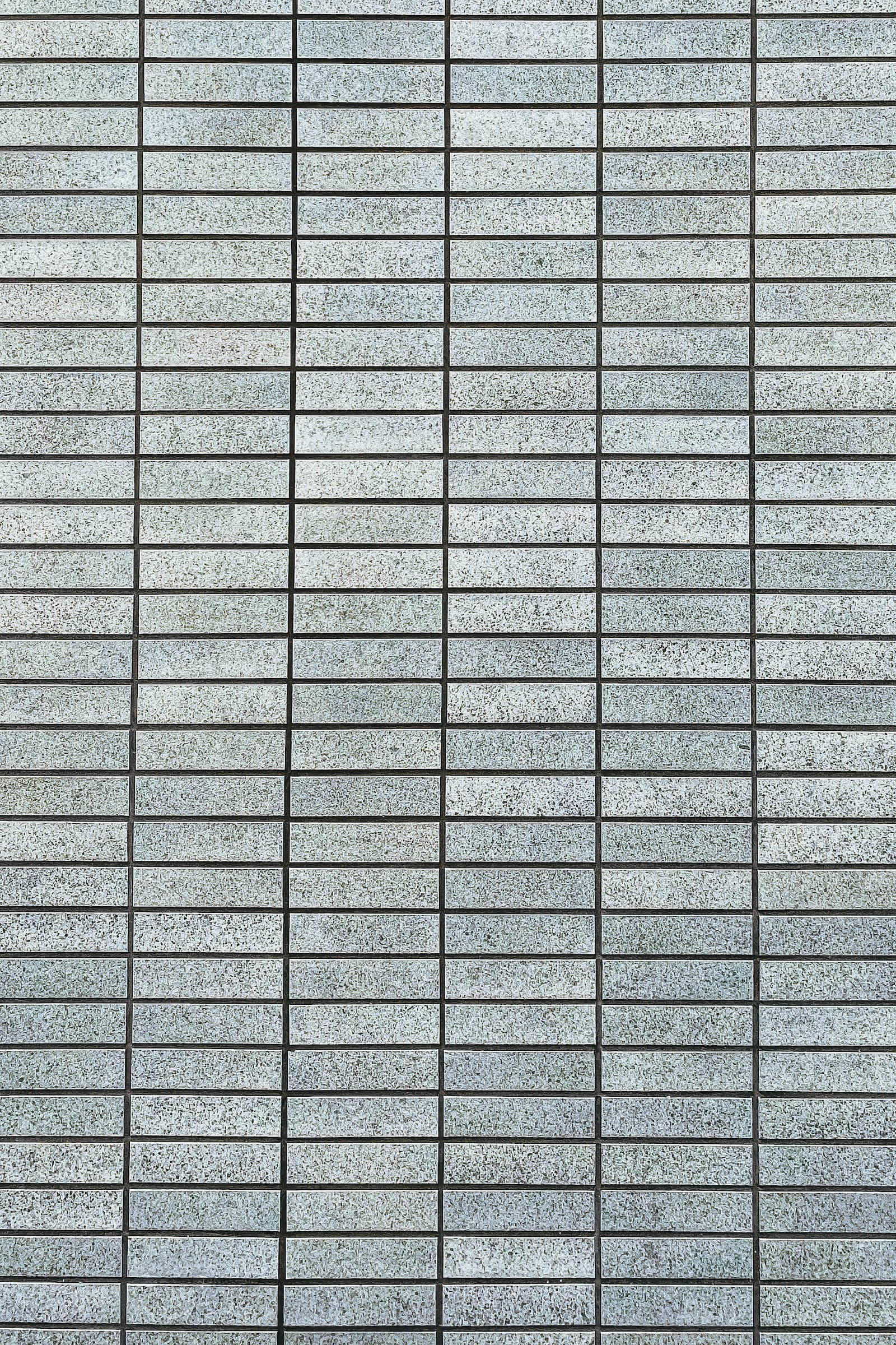 Plain Grey 桌布 壁紙 — 現代灰色磚牆的特寫，深色填縫線形成精確的網格圖案。