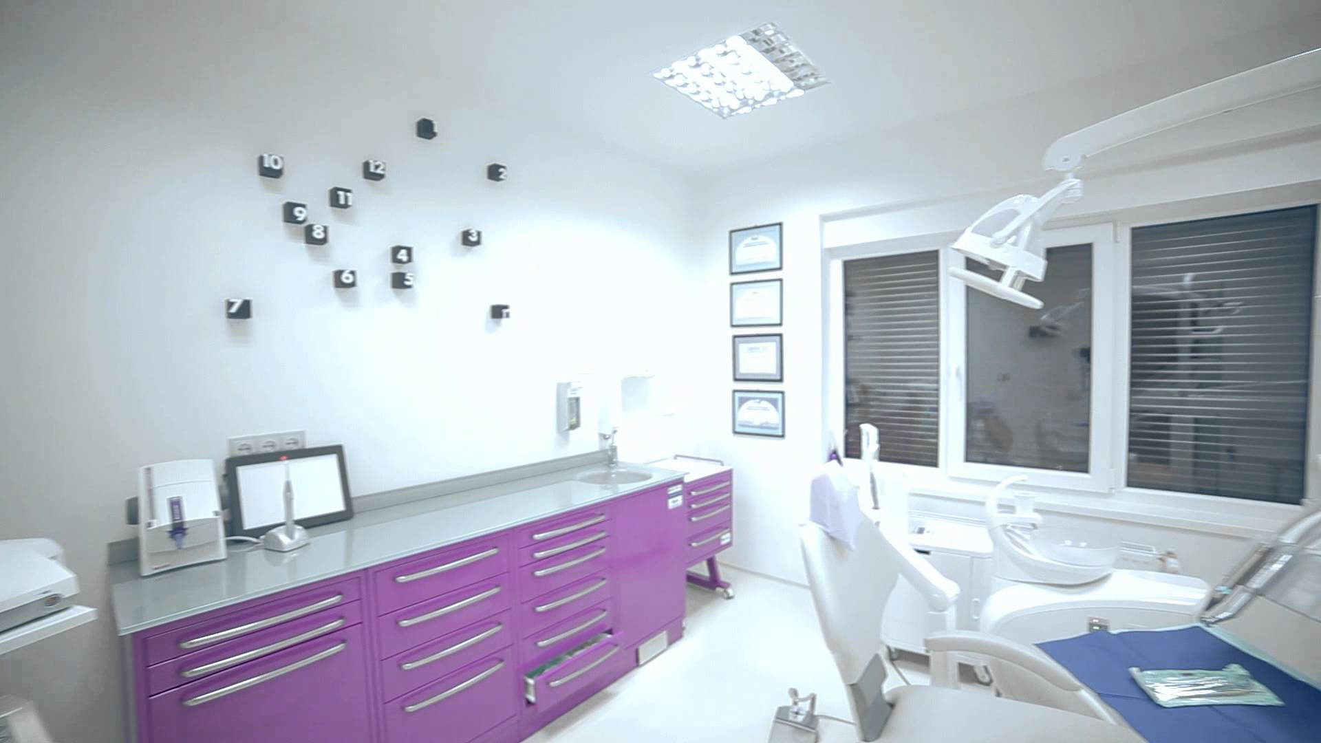 Dentistry 桌布 壁紙 — 現代牙科診所，配有紫色櫃子、白色牆壁和明亮天花燈光下的病人椅。