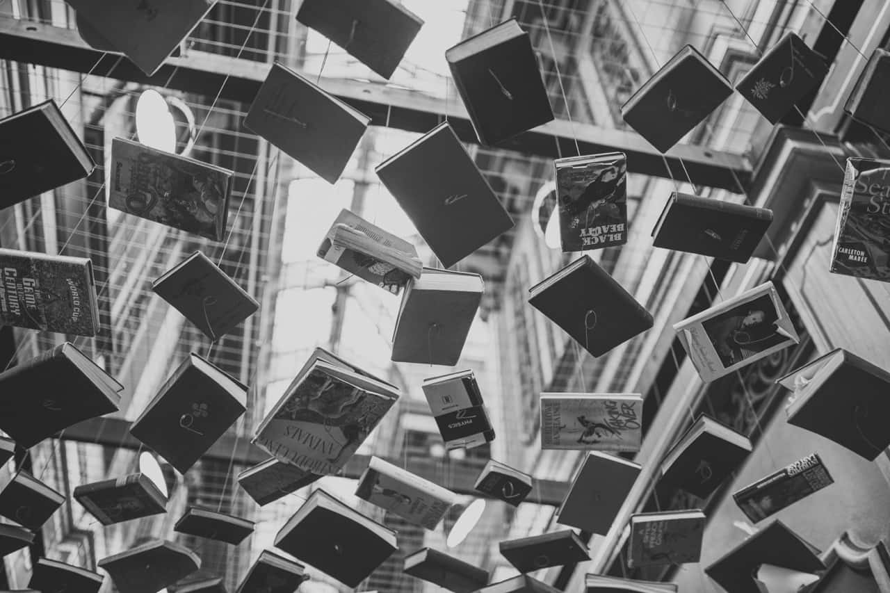 Black And White Book 桌布 壁紙 — 現代玻璃中庭天花板上用金屬線懸掛的書籍黑白照片。