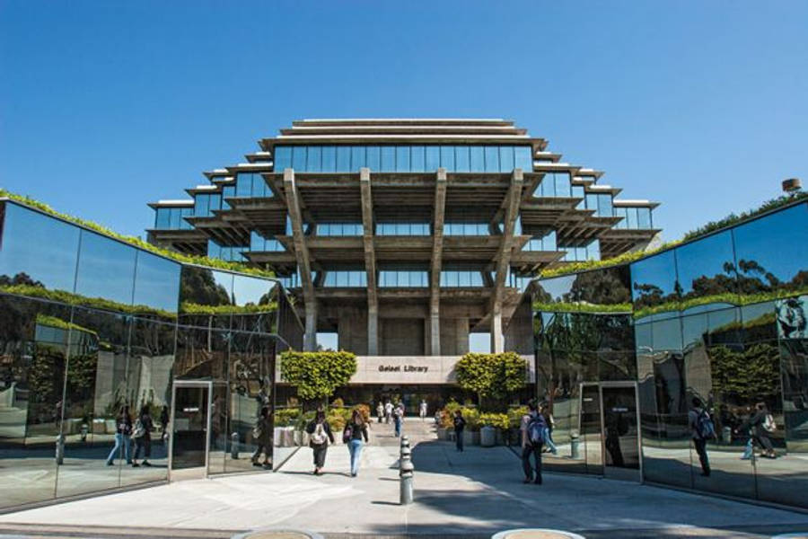 Architecture 桌布 壁紙 — 現代玻璃和混凝土圖書館，階梯式屋頂反射藍天和綠意，人們走過入口。