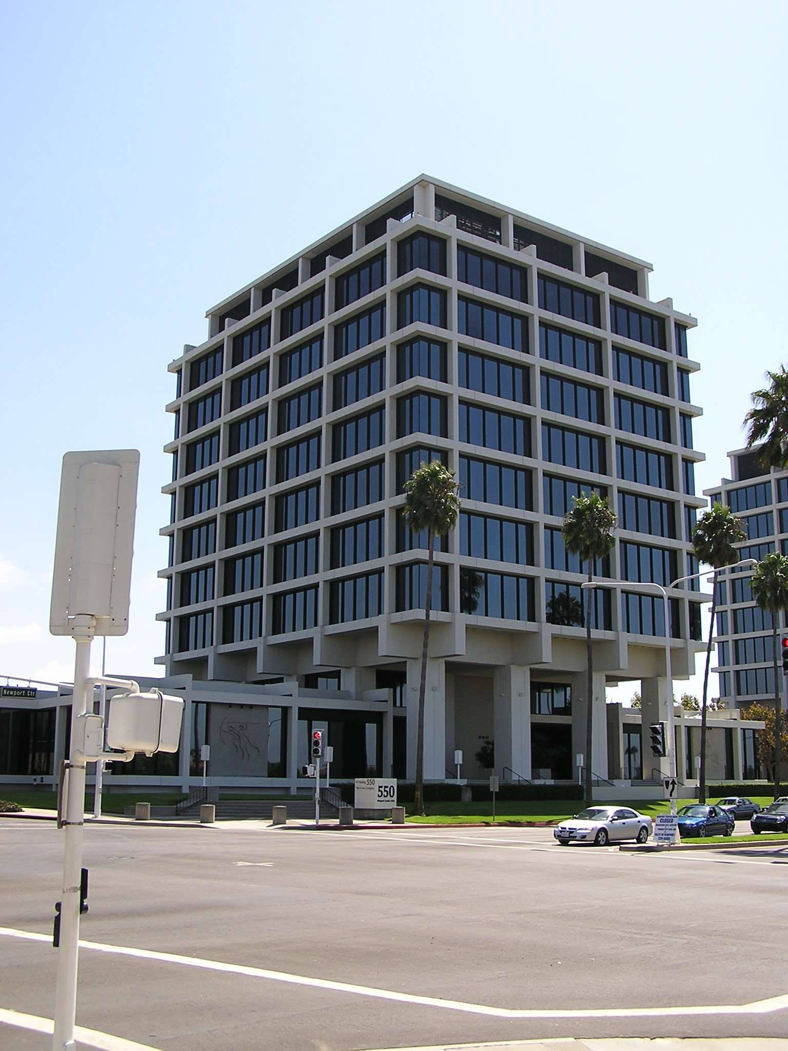 Architecture 桌布 壁紙 — 現代玻璃和混凝土辦公大樓，棕櫚樹高聳在晴朗的藍天下，街道上有汽車。