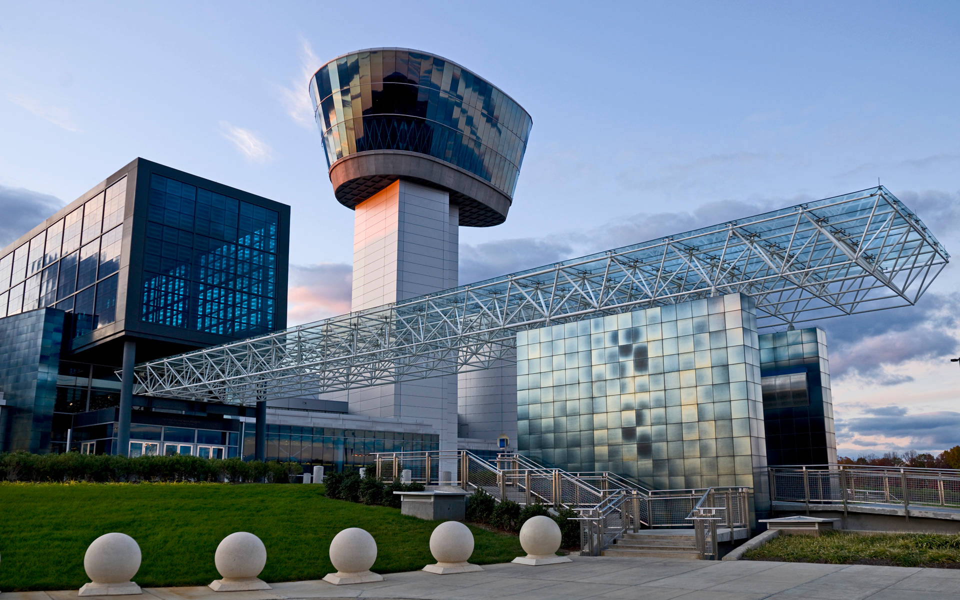 Smithsonian 桌布 壁紙 — 現代玻璃和鋼結構機場控制塔和航廈沐浴在金色的日落光中。