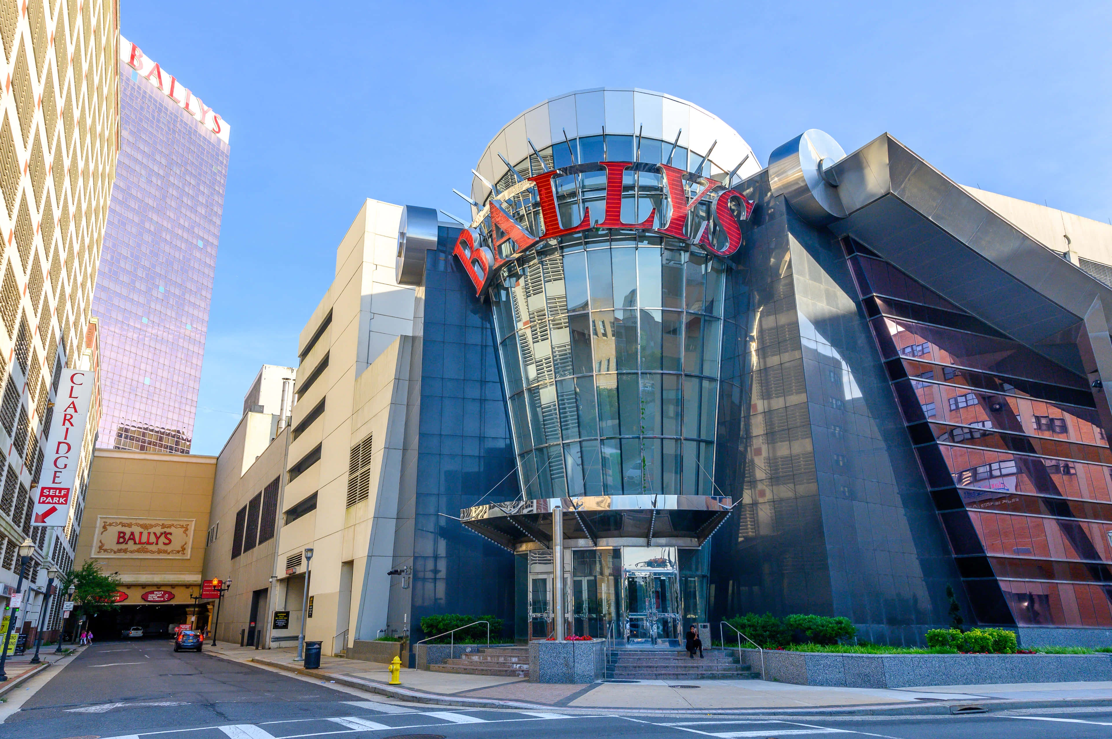 飯店 桌布 壁紙 — 現代玻璃和鋼結構的Bally's賭場建築，在晴朗藍天下帶有醒目的紅色標牌。