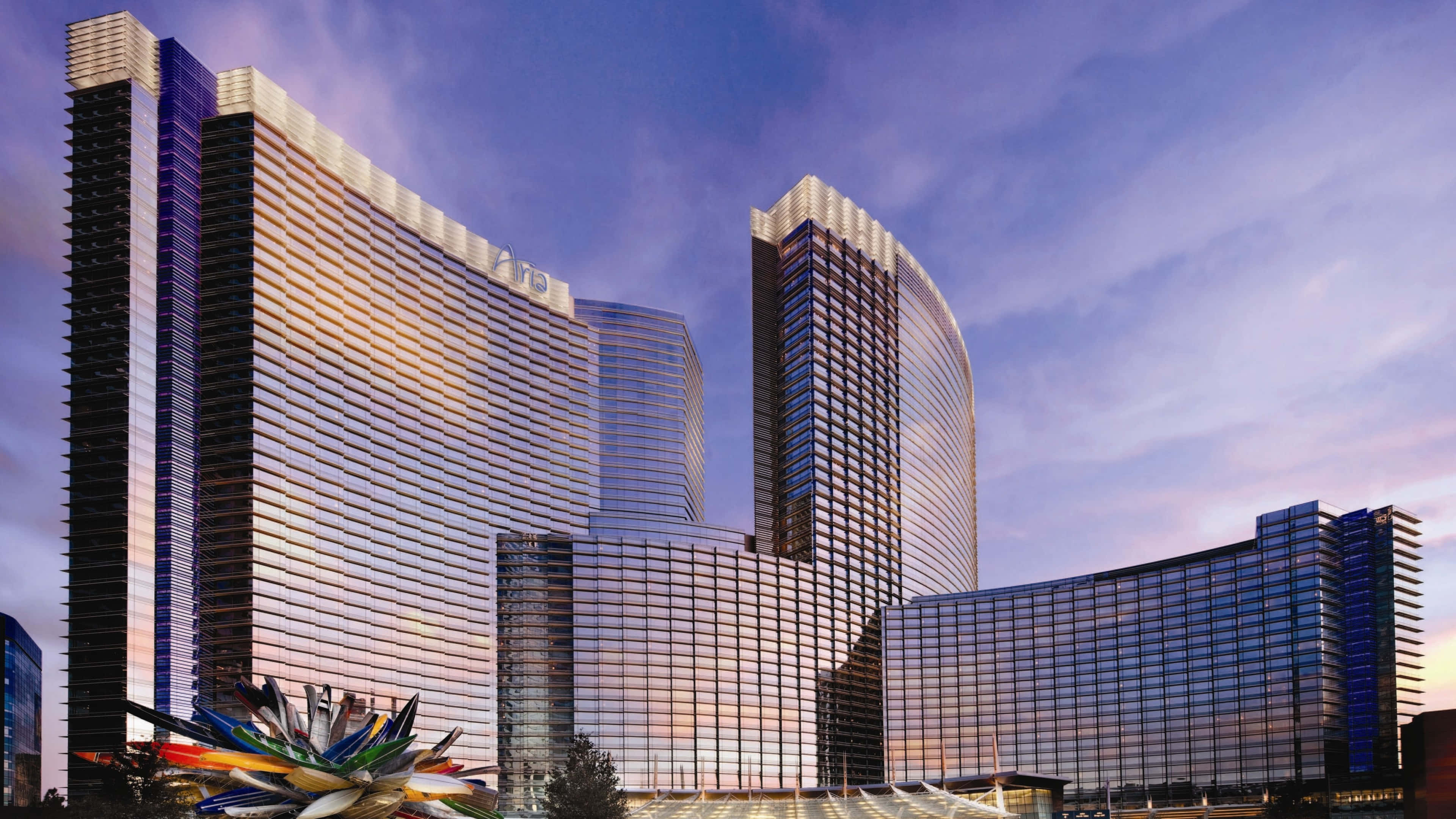 Las Vegas 桌布 壁紙 — 現代玻璃摩天大樓，弧形外牆在暮色天空中反射出夕陽的色彩。