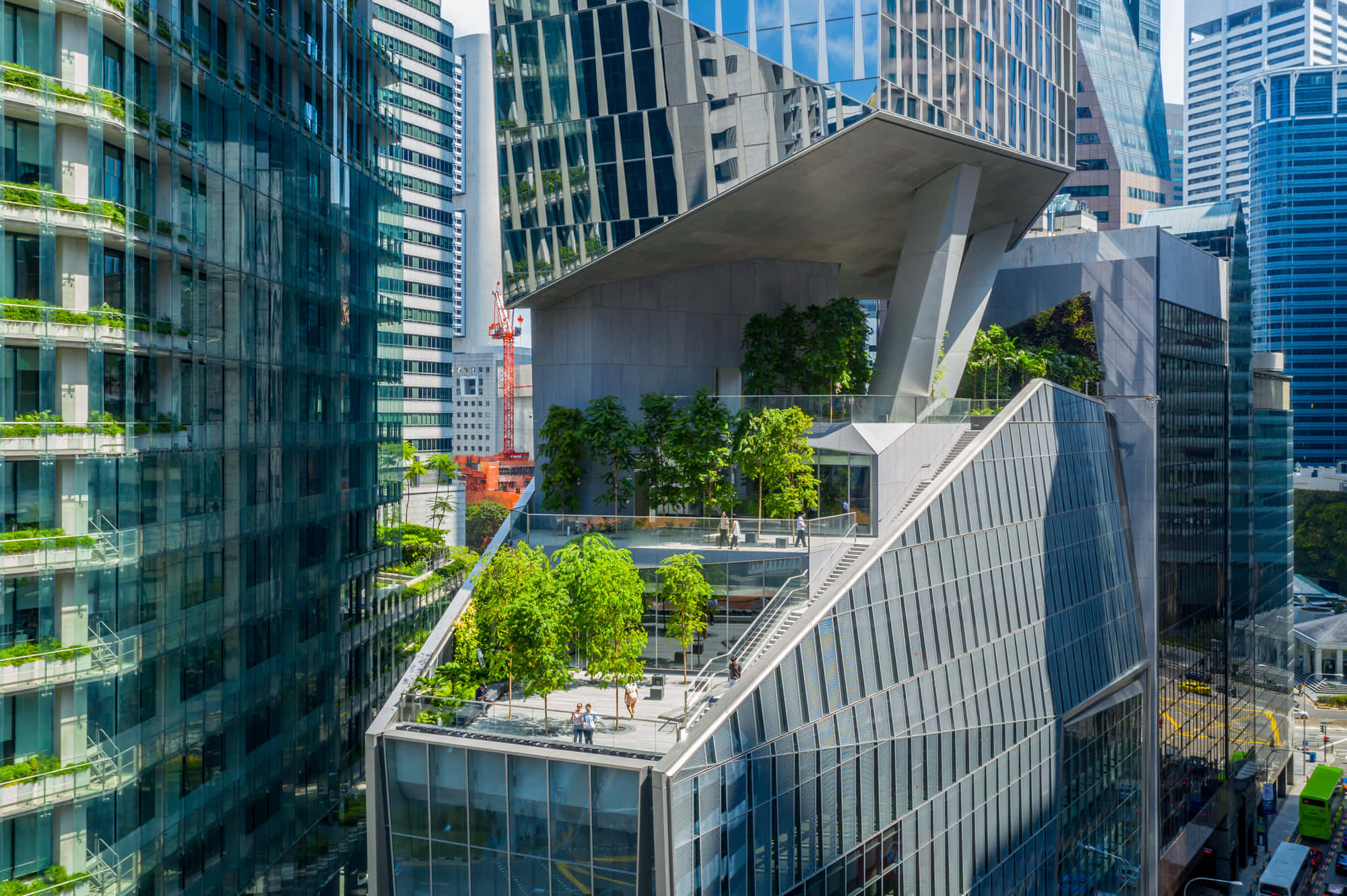 Green Buildings 桌布 壁紙 — 現代玻璃摩天大樓，擁有茂密的綠色屋頂和露台，位於繁華的城市峽谷中，在明亮的日光下。