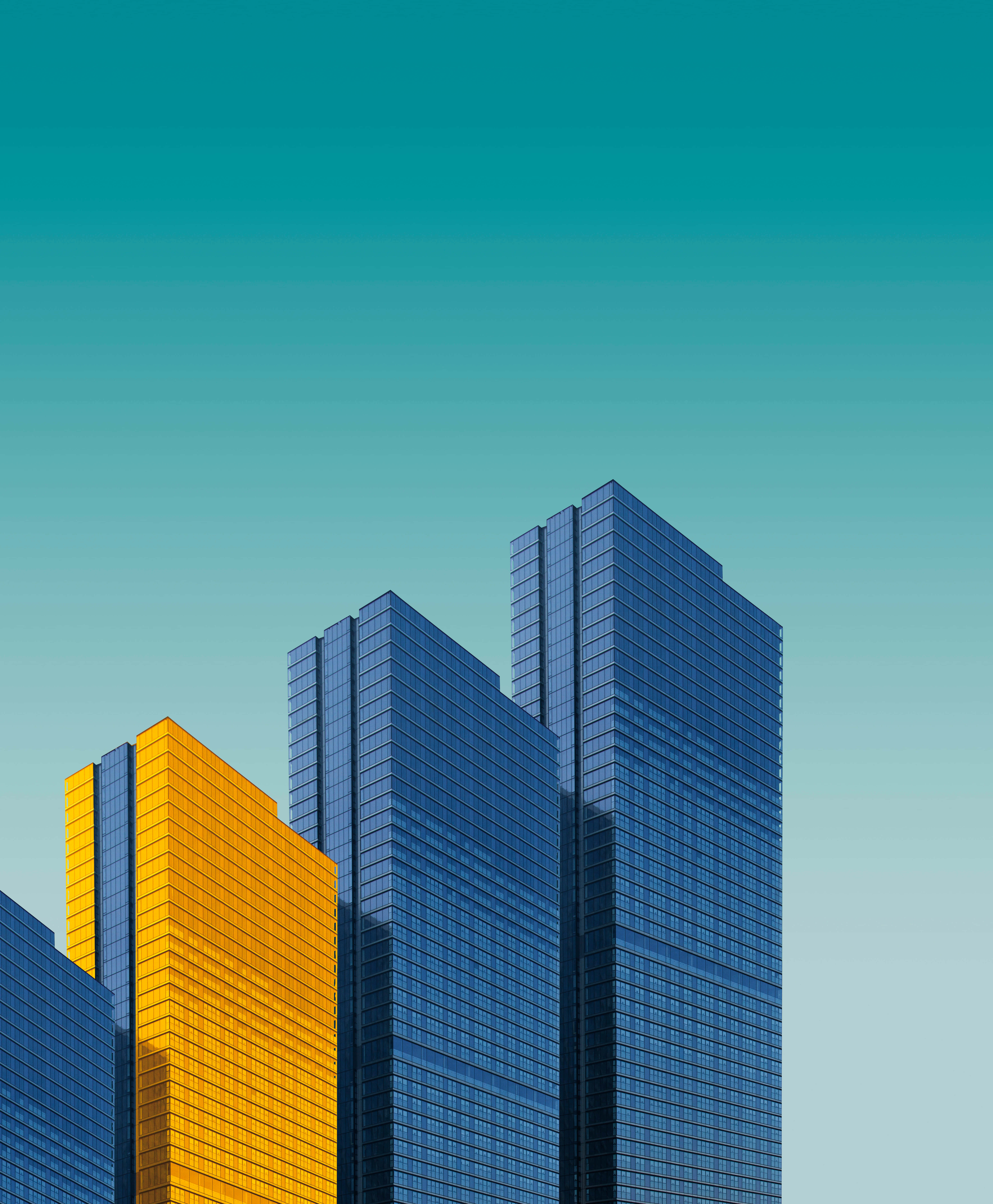3d City 桌布 壁紙 — 現代玻璃摩天大樓在漸層青綠色天空的映襯下拔地而起，其中一棟建築閃耀著金色光芒。