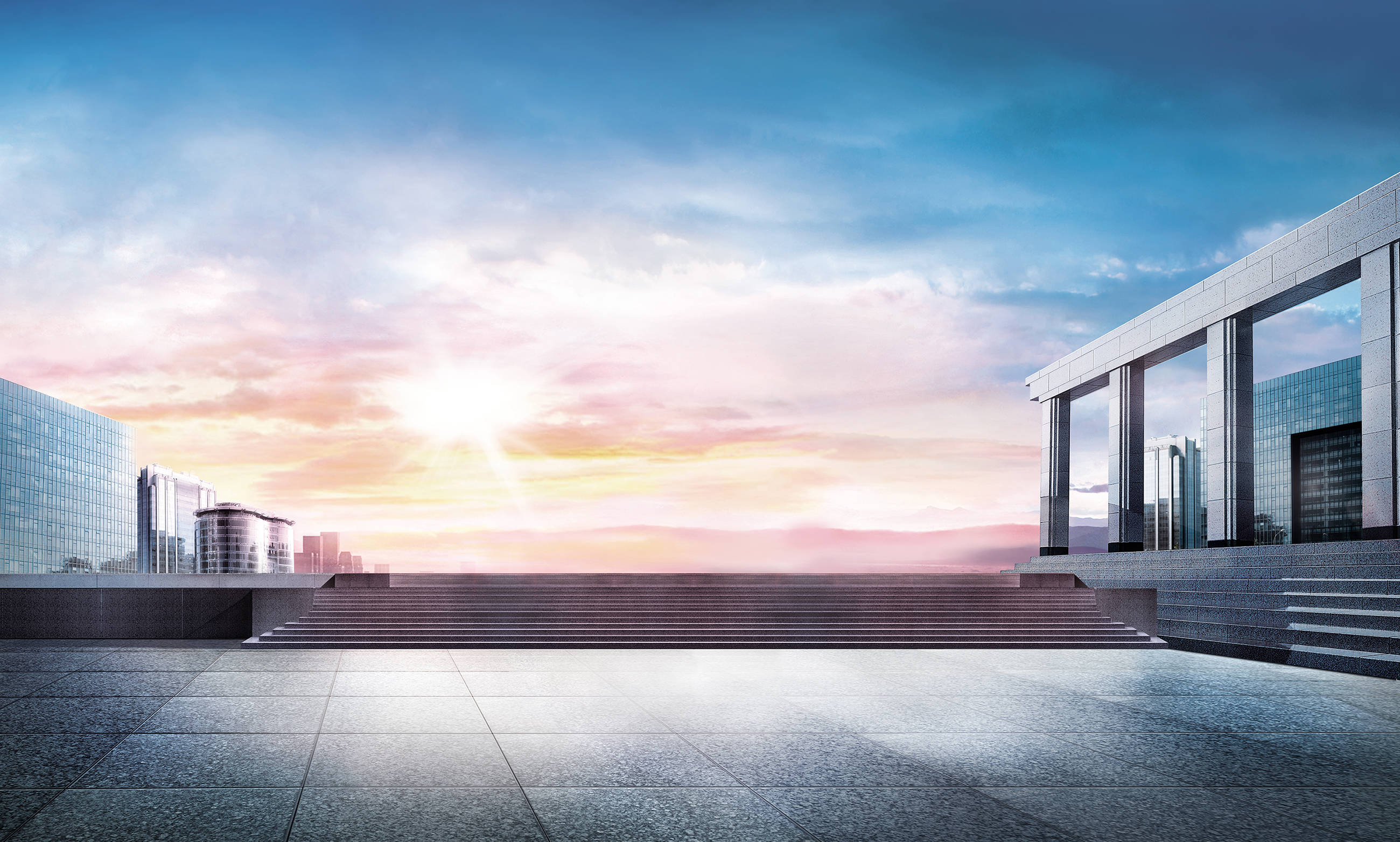 Estate 桌布 壁紙 — 現代玻璃與石材建築，沐浴在溫暖的夕陽餘暉中，映襯著充滿活力的天空。