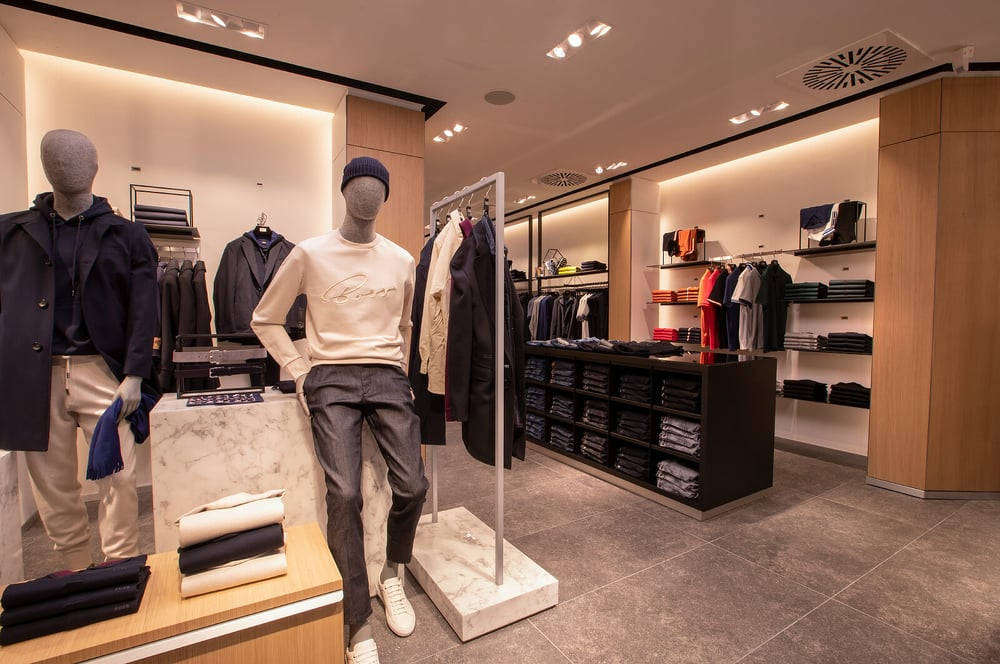 Clothes 桌布 壁紙 — 現代男裝店，人體模型穿著時尚服裝，在溫暖的環境燈光下。