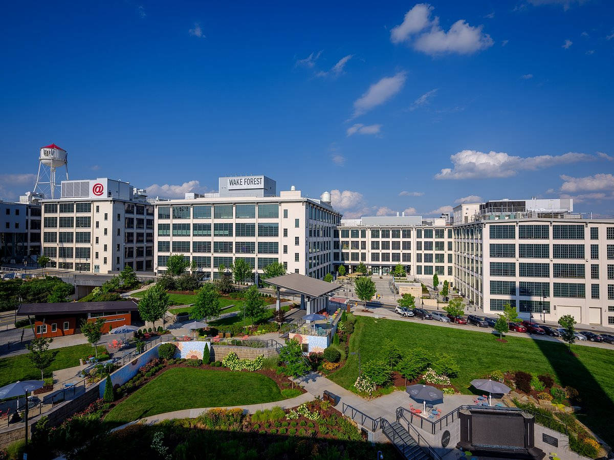 學校 桌布 壁紙 — 現代白色大學建築，在明亮的藍天白雲和茂盛綠色景觀下。