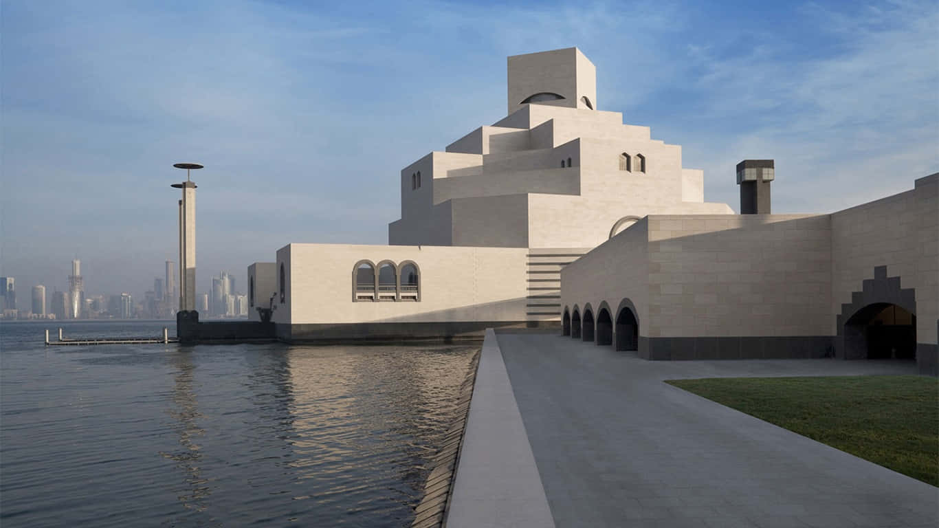 建築 桌布 壁紙 — 現代白色幾何博物館建築，帶有拱形窗戶，矗立在海濱，反射天空和城市天際線的背景。