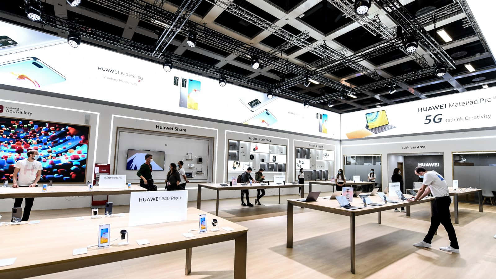 華為電子產品店，顧客正在瀏覽展示桌上的設備。