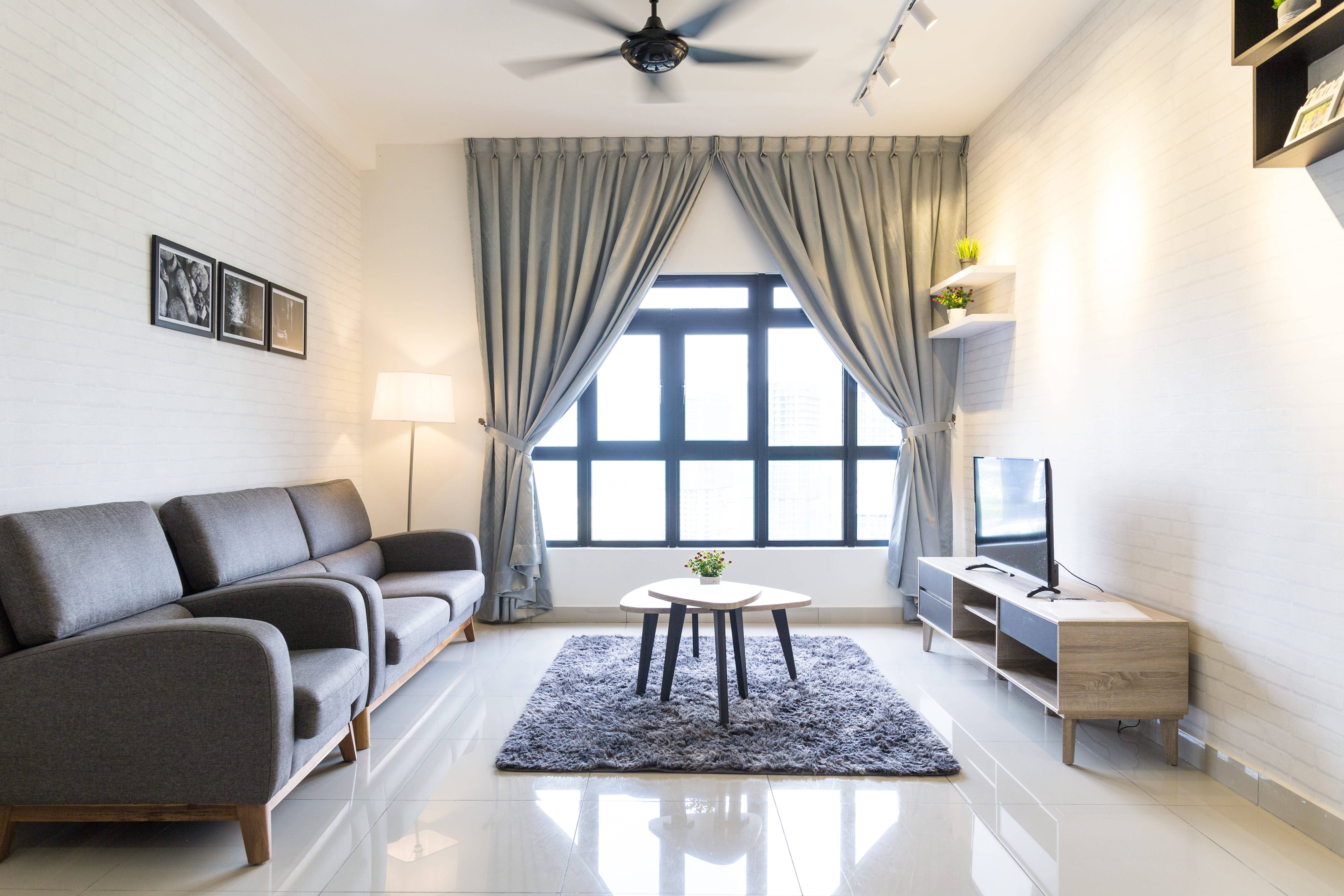 Aesthetic Home 桌布 壁紙 — 現代簡約客廳，配有灰色沙發、白色磚牆和掛有灰色窗簾的大窗戶。