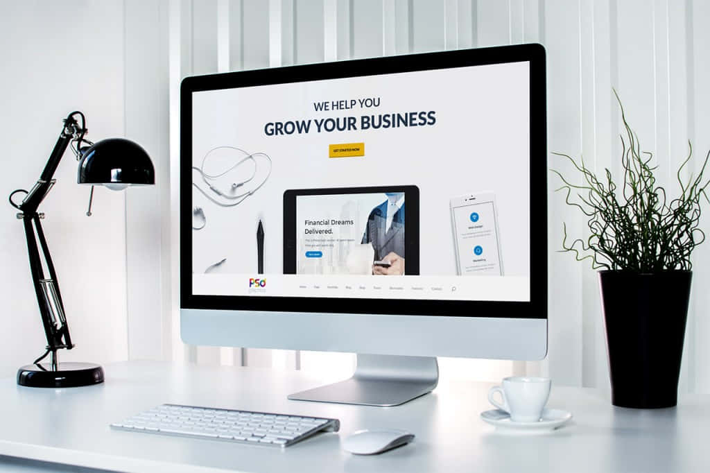 Website 桌布 壁紙 — 現代簡約辦公桌設置，配備時尚 iMac 顯示商業成長網站，旁邊有黑色檯燈和盆栽植物。