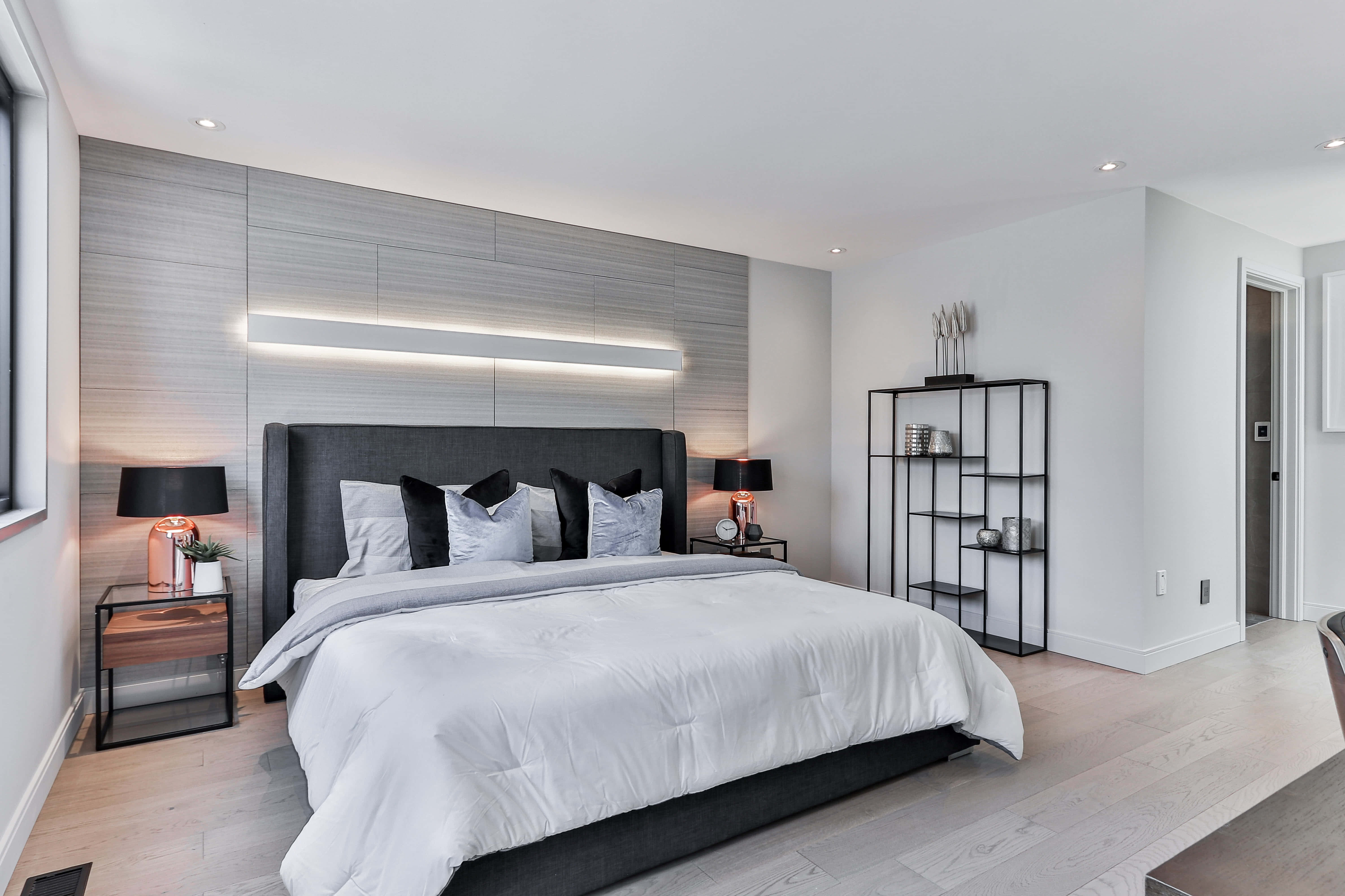 Bedroom 桌布 壁紙 — 現代簡約風格臥室，配備大床，位於灰色紋理牆下，設有環境照明和時尚黑色家具。